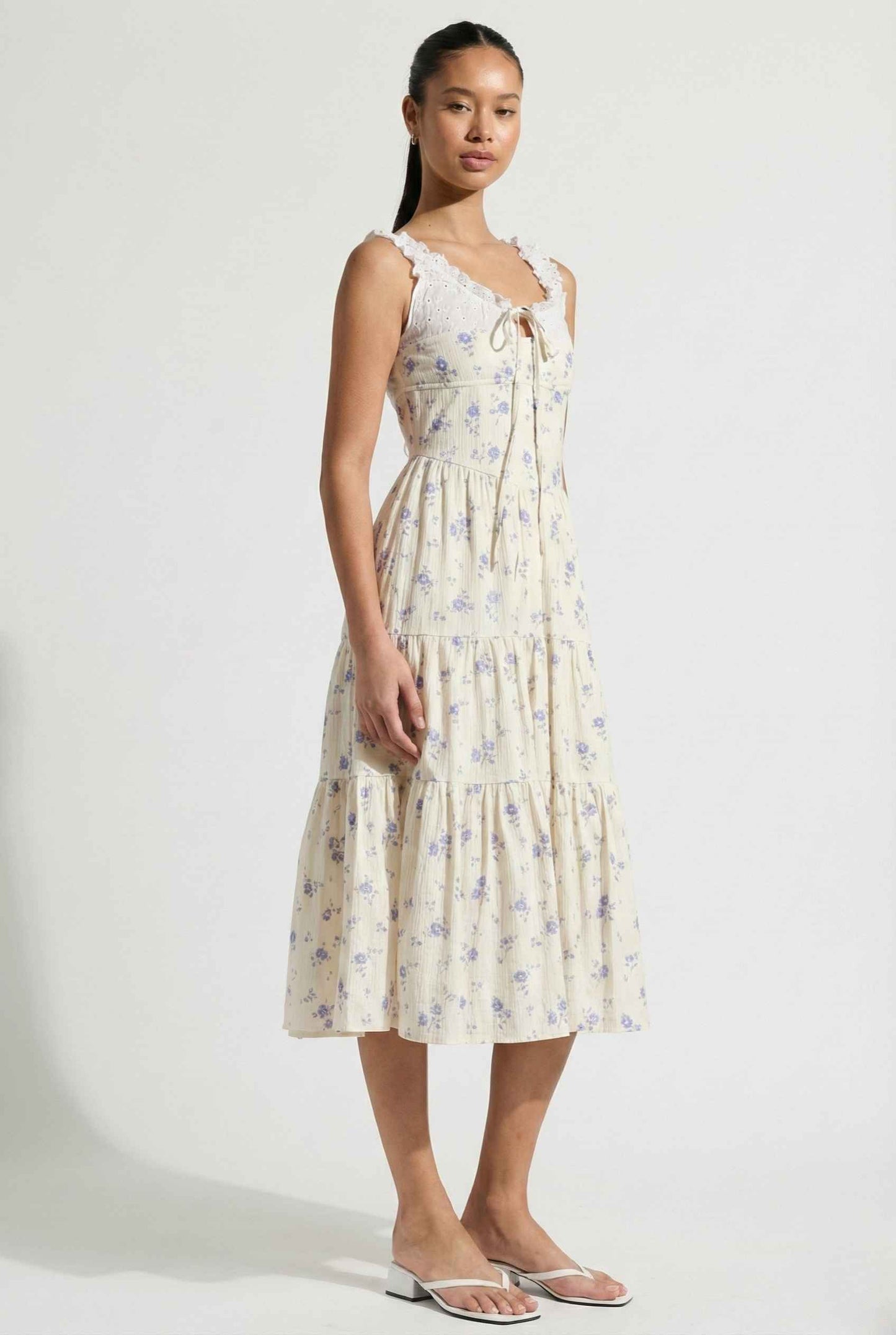 Woman wearing a Adeline Midi | Ivory Floral Eyelet Tiered Dress against a white background