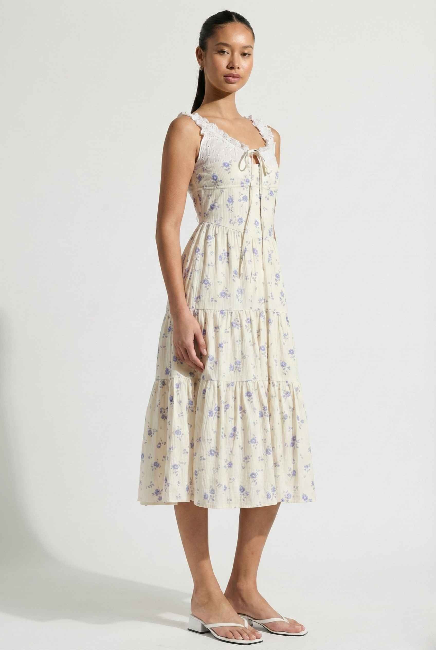 Woman wearing a Adeline Midi | Ivory Floral Eyelet Tiered Dress against a white background