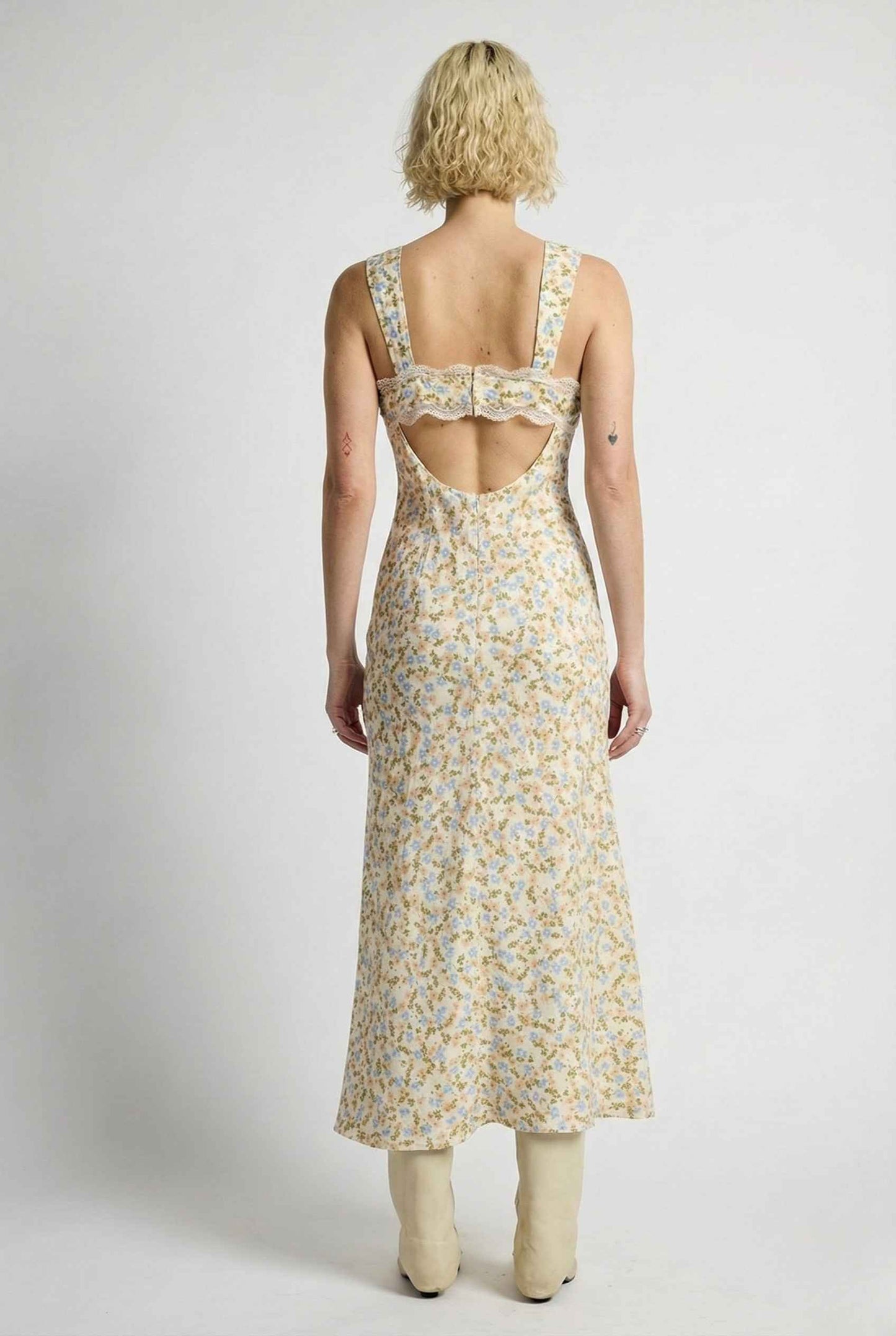 Woman wearing a Amelie Midi Cutout Yellow Floral Rayon Blend Dress with cut-out back on a white background