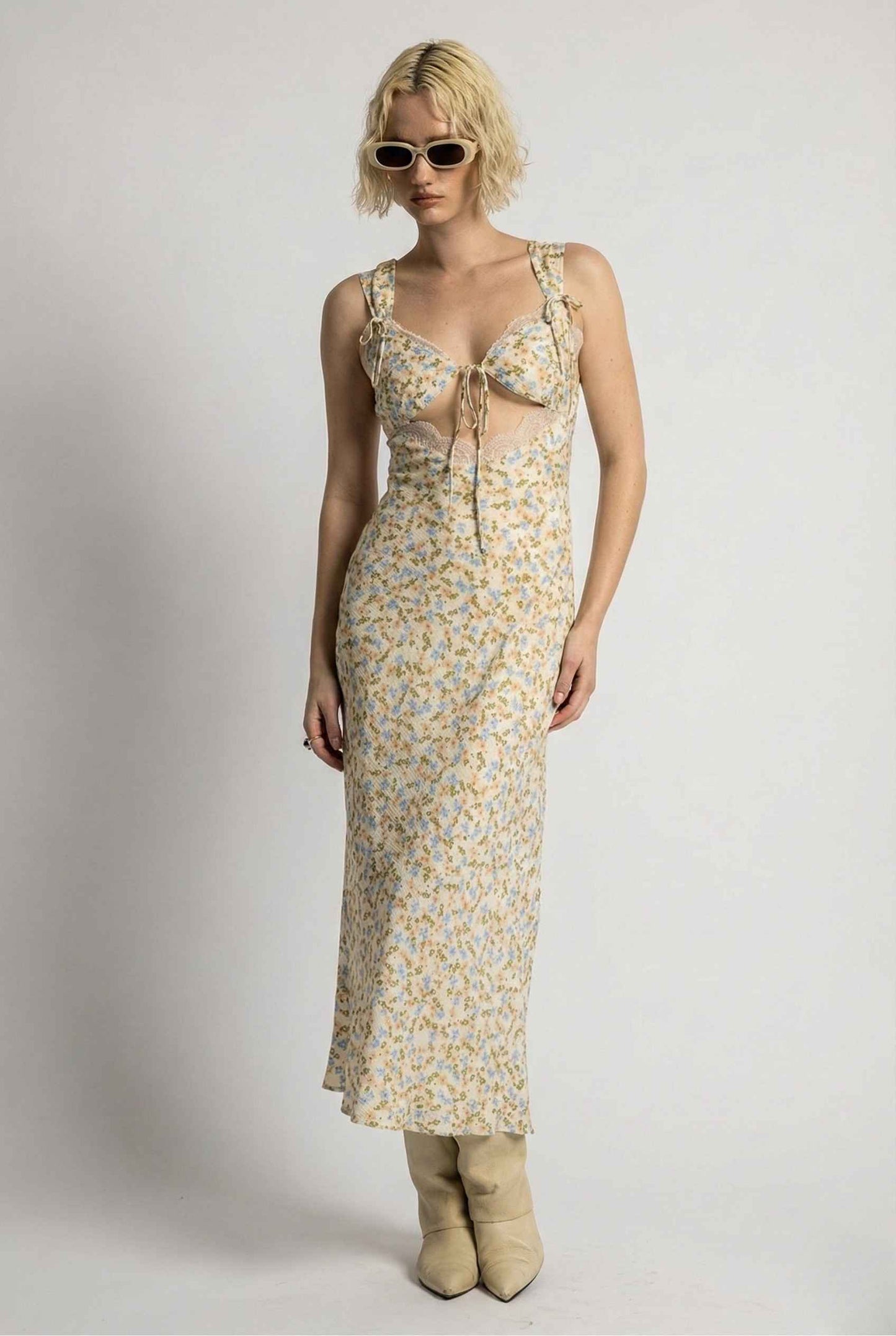 Woman wearing a Amelie Midi Cutout Yellow Floral Rayon Blend Dress with sunglasses on a plain background