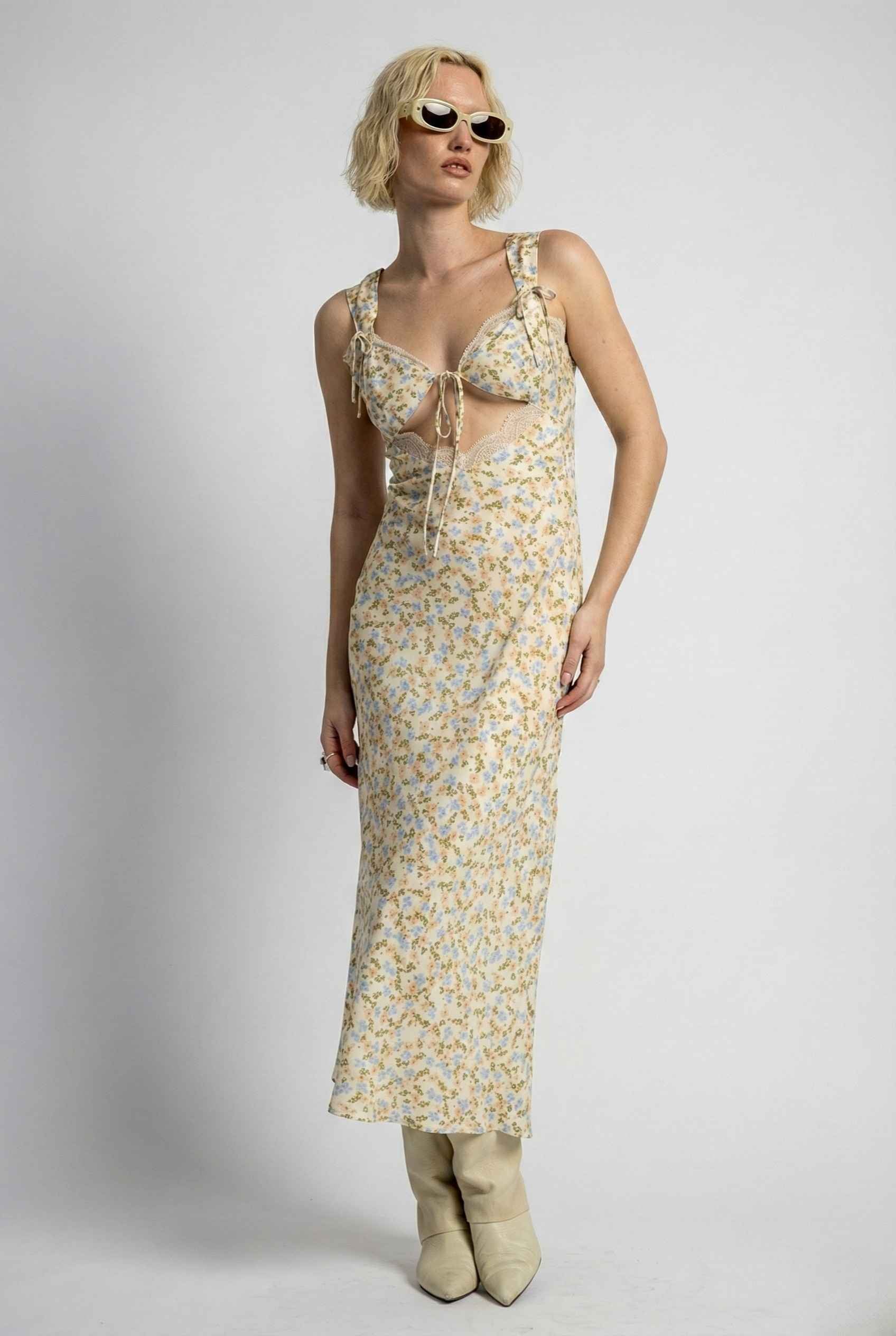 Woman wearing a Amelie Midi Cutout Yellow Floral Rayon Blend Dress with sunglasses on a plain background