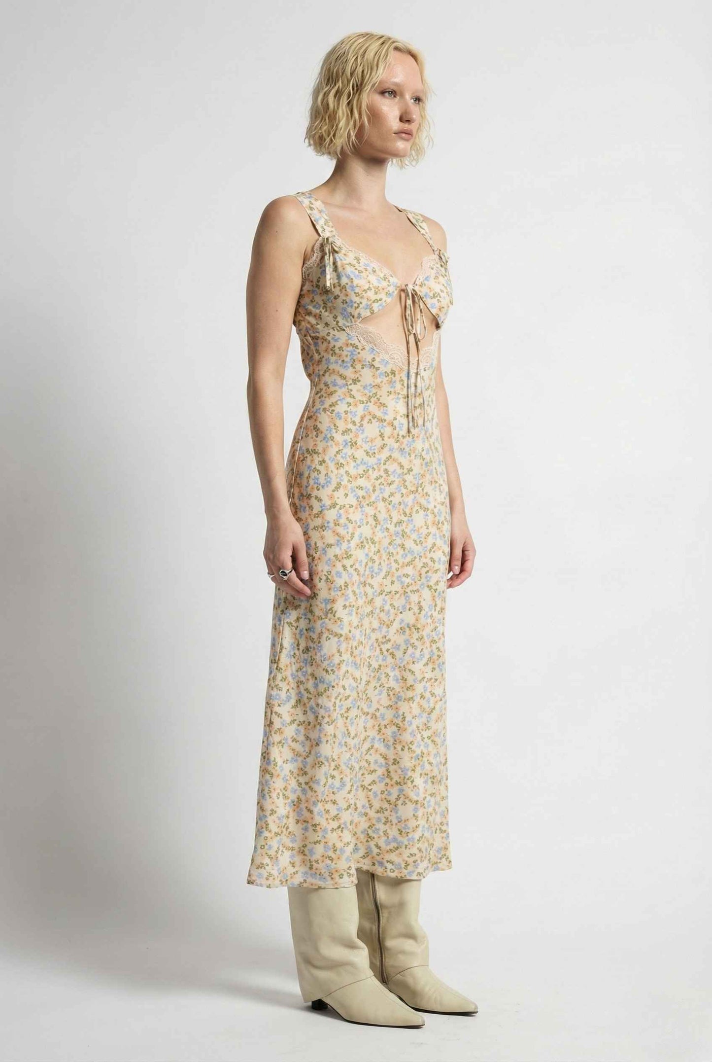 Woman wearing a Amelie Midi Cutout Yellow Floral Rayon Blend Dress with beige boots on a white background