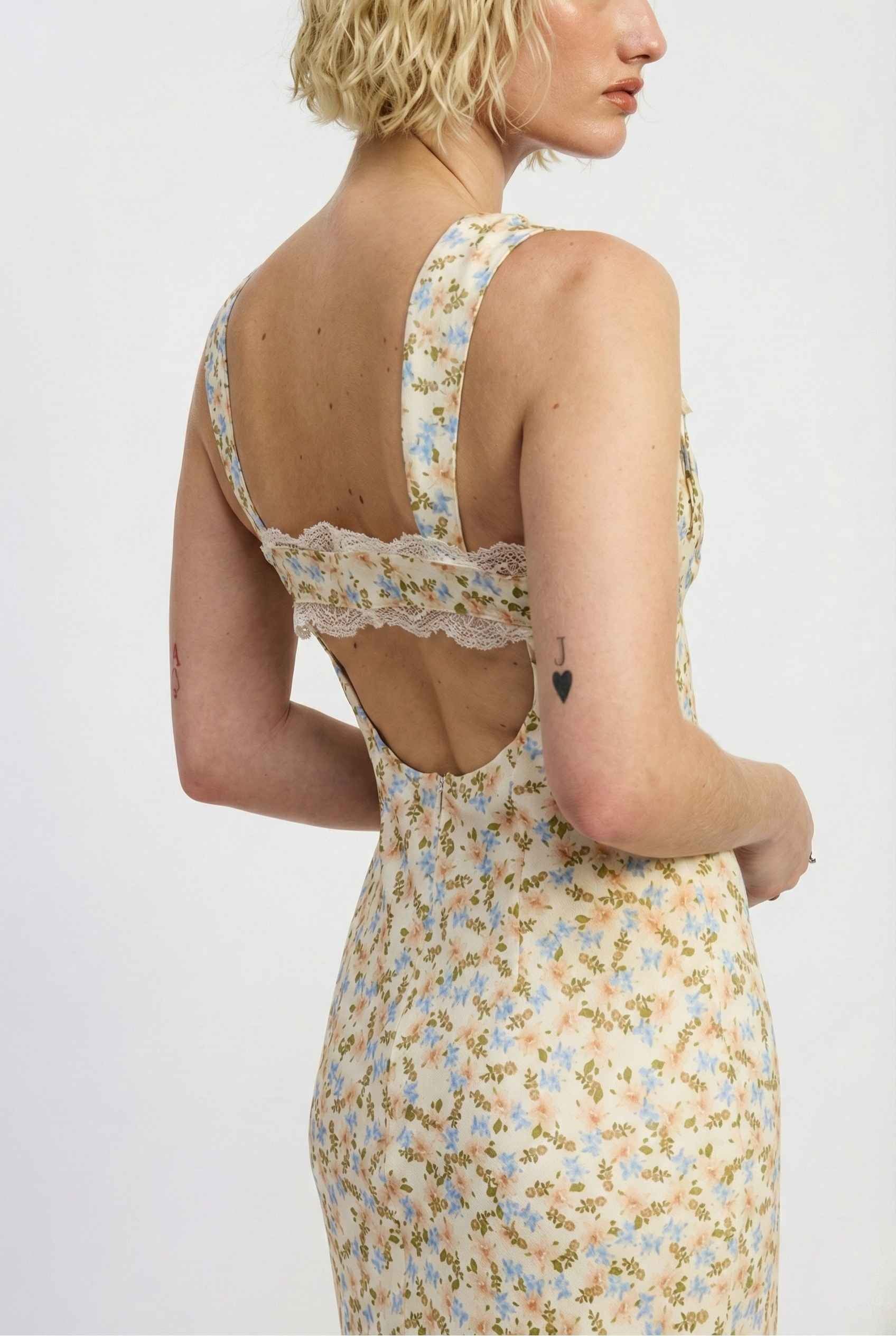 Woman wearing a Amelie Midi Cutout Yellow Floral Rayon Blend Dress with a lace back on a white background