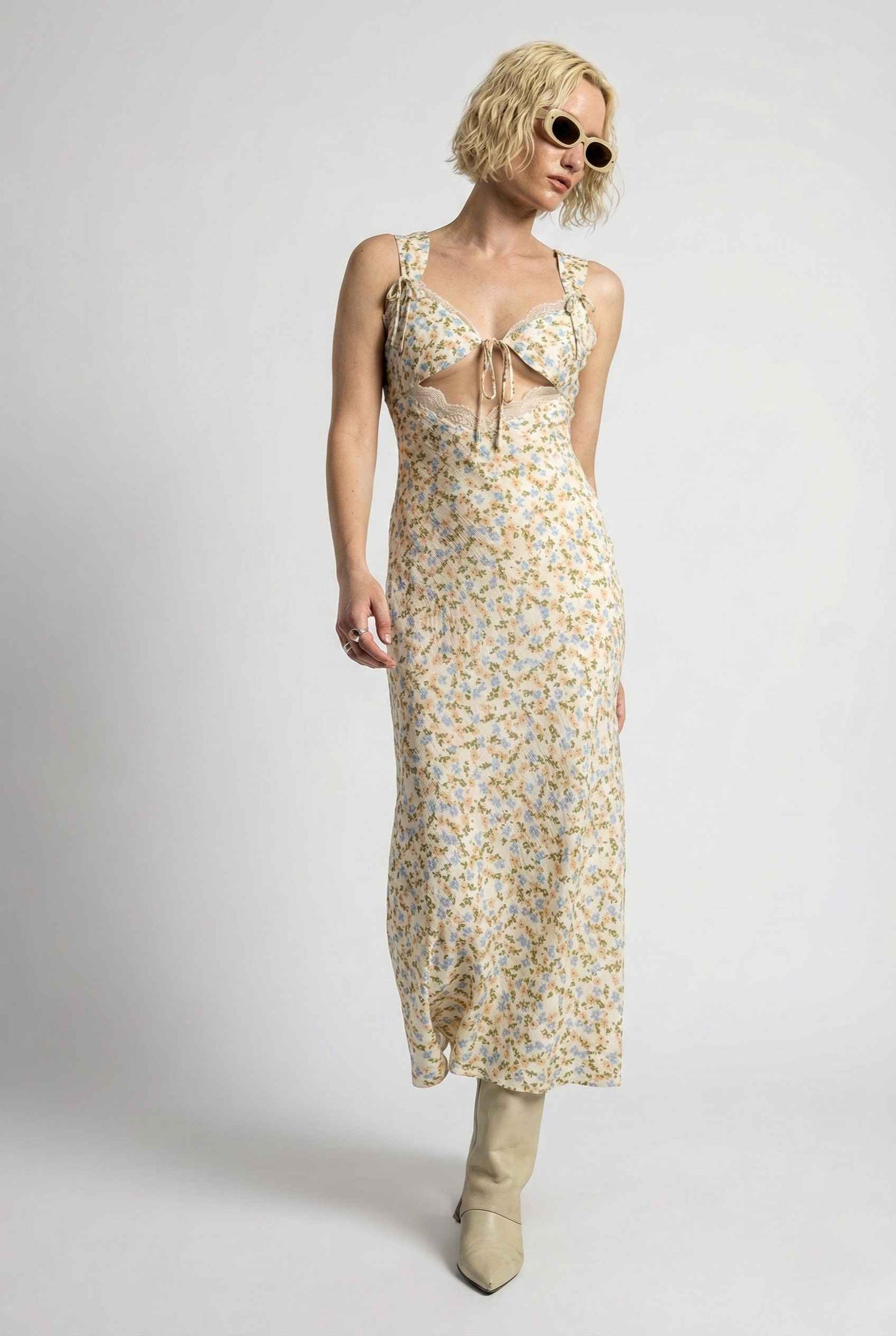 Woman wearing a Amelie Midi Cutout Yellow Floral Rayon Blend Dress with sunglasses on a white background