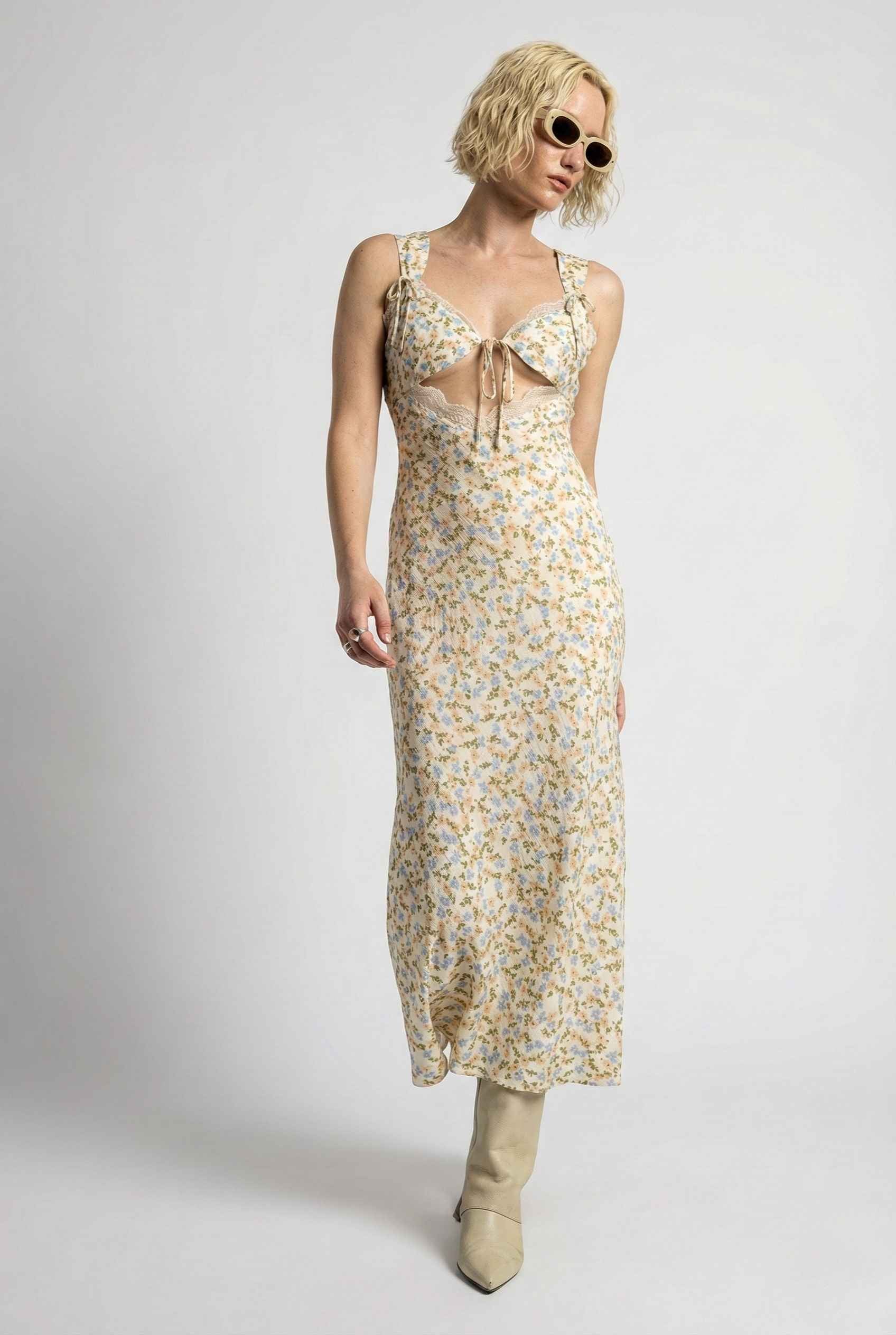 Woman wearing a Amelie Midi Cutout Yellow Floral Rayon Blend Dress with sunglasses on a white background