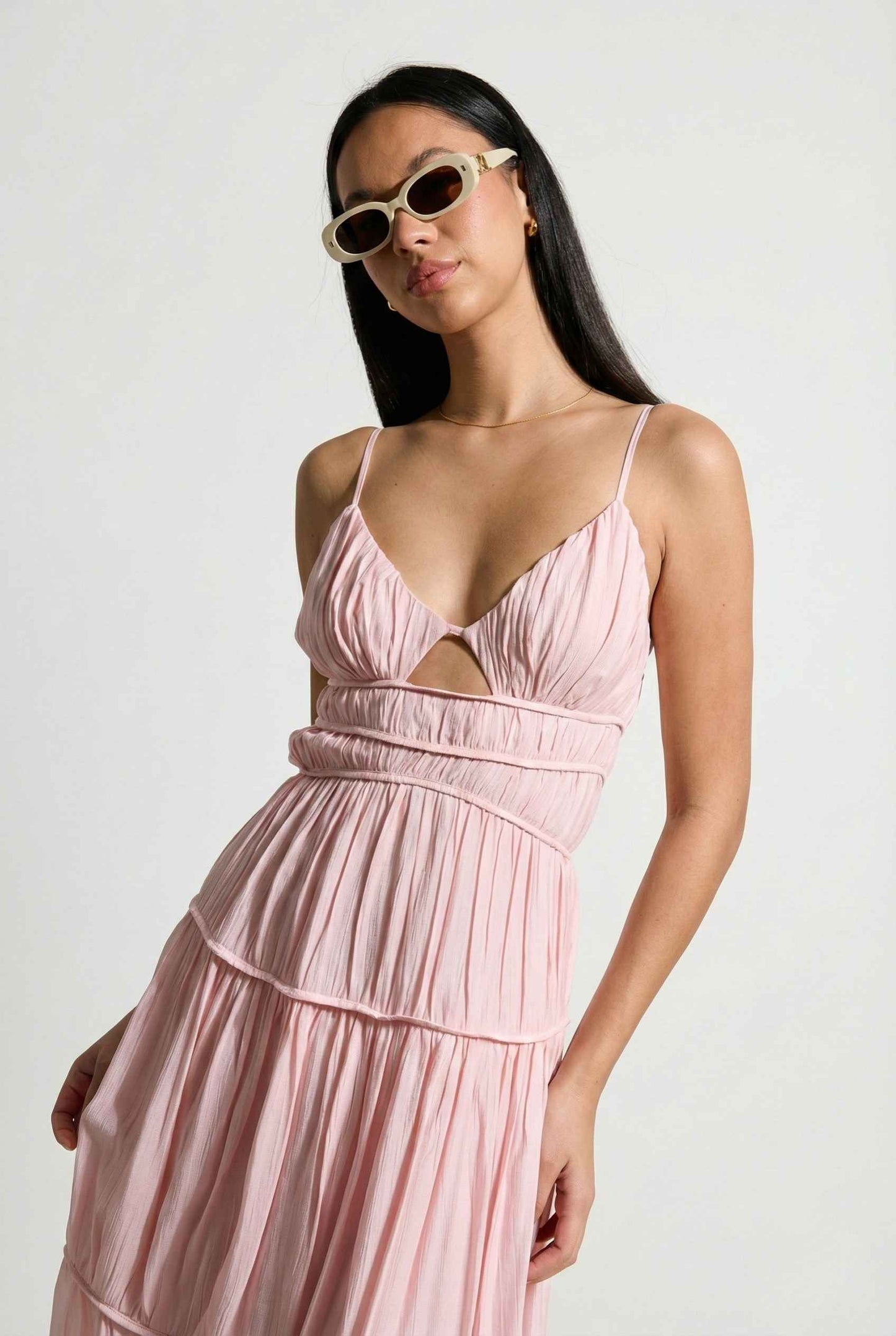 Woman wearing a Aria Maxi Pink Tiered Cutout Dress with cut-out design on a white background