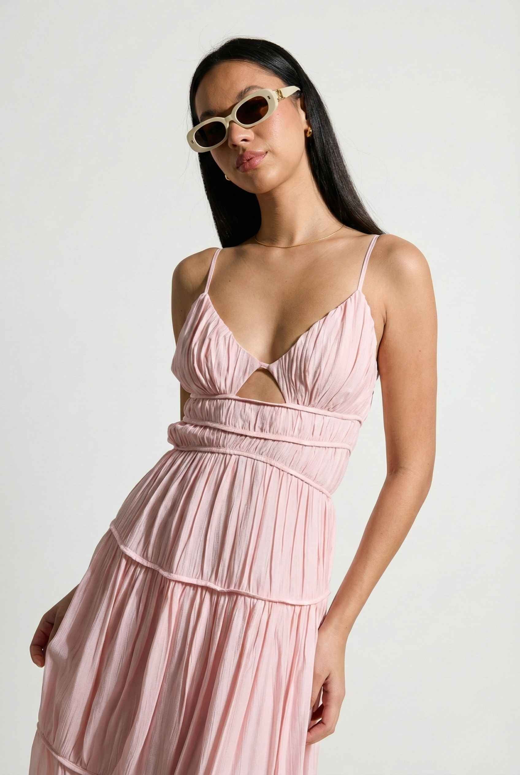 Woman wearing a Aria Maxi Pink Tiered Cutout Dress with cut-out design on a white background