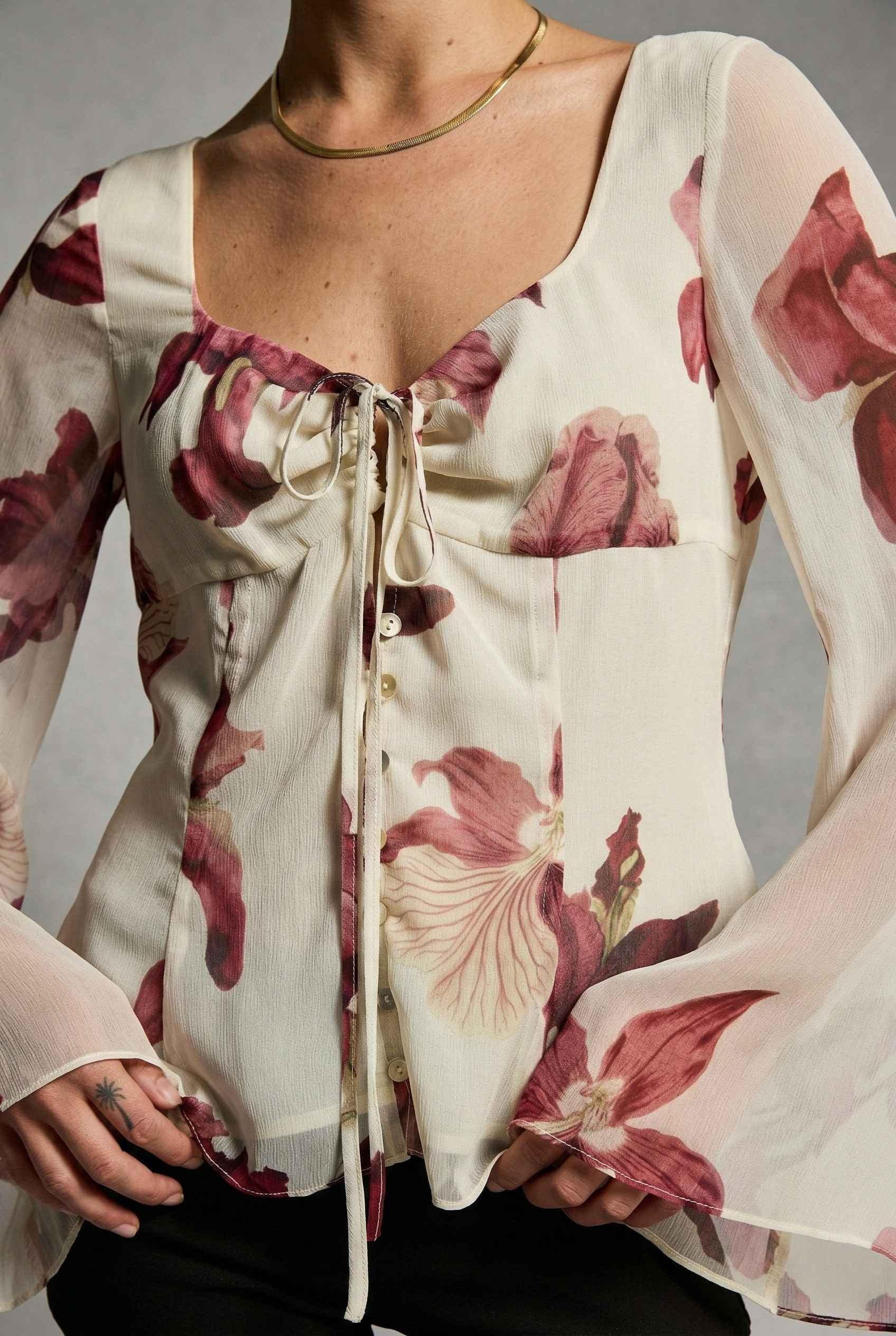 Aria Top Ivory Floral Tie-Front Bell Sleeve Blouse and a drawstring neckline on a neutral background
