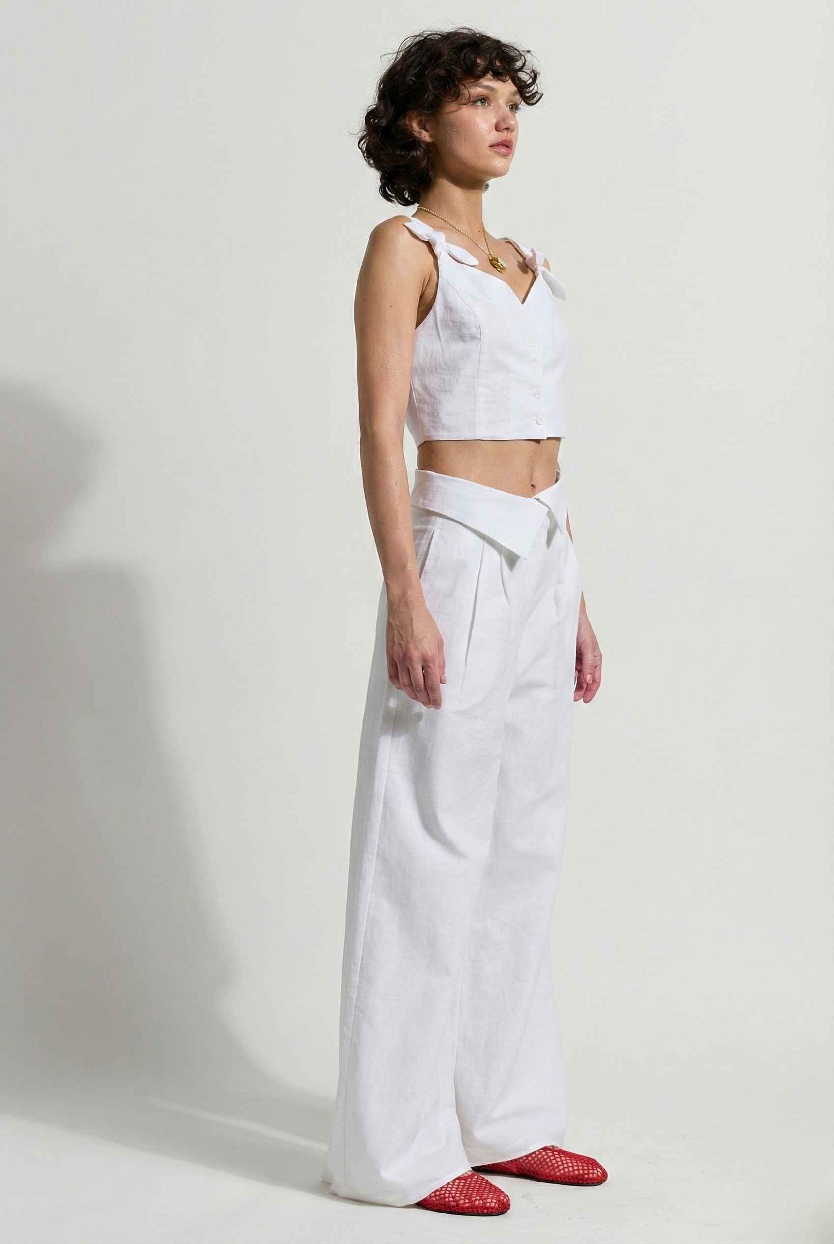 Woman wearing a Aria Top White Linen Blend Button Front Tie Crop Top. 