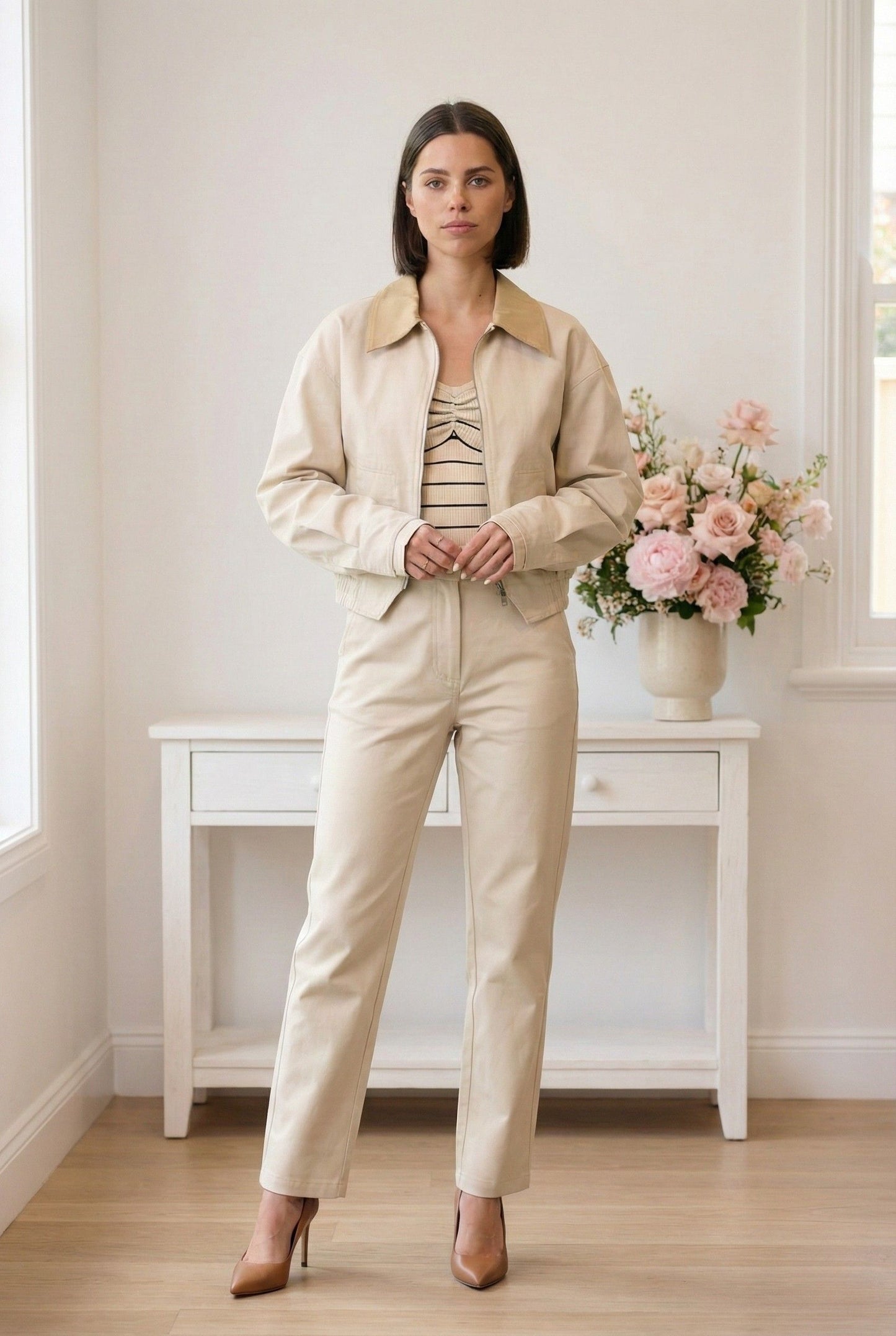 Model wearing Arlo Jacket | Beige Lyocell-Blend Jacket with Contrast Collar with striped shirt, straight leg pants and heels standing in minimalist room