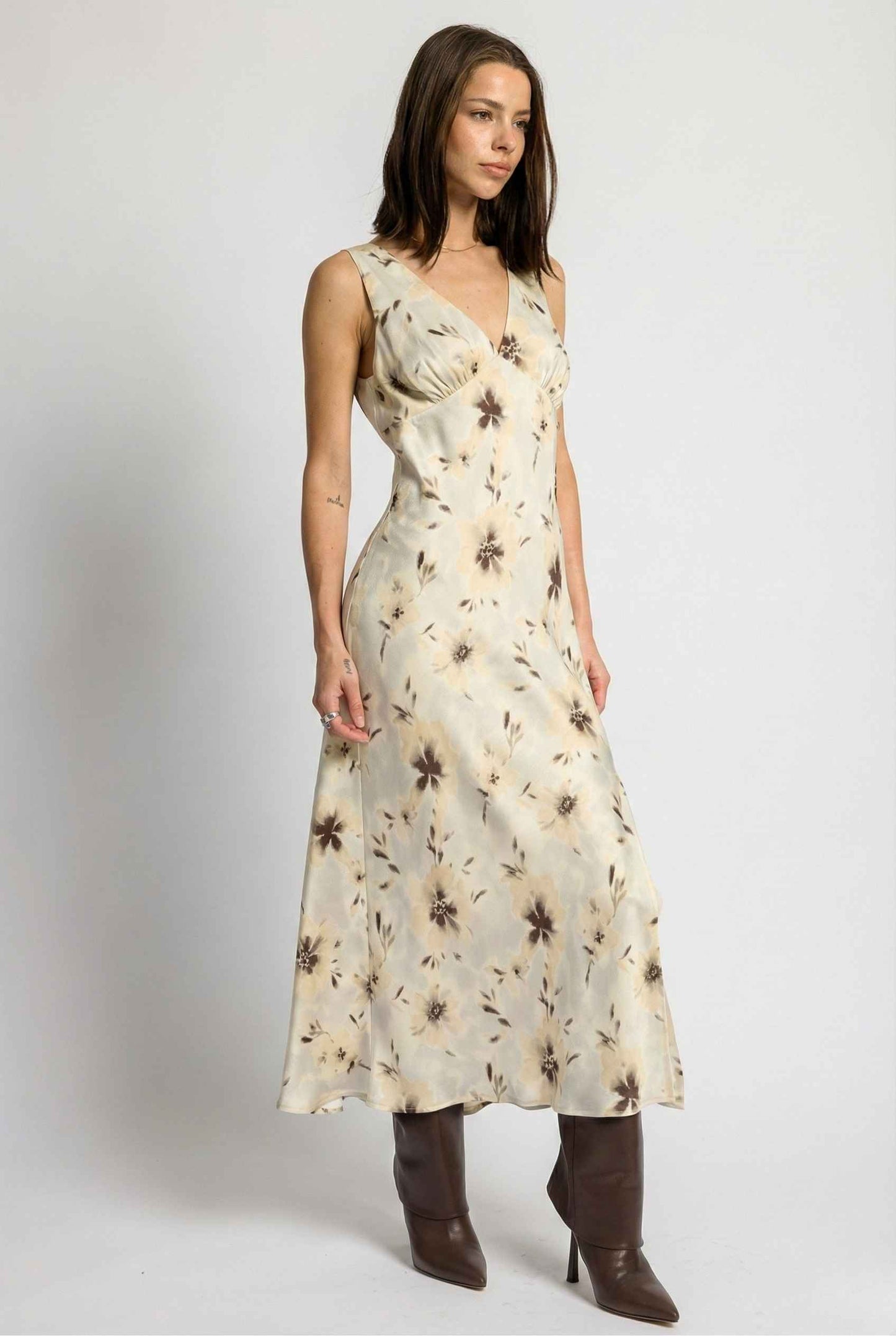 Woman wearing a Aurelia Midi Ivory Sepia Floral V-Neck Slit Dress with brown boots on a white background