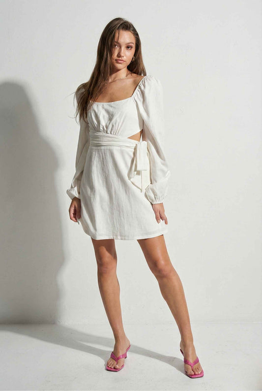 Woman wearing a Aurelia Mini White Long Sleeve Cutout Dress with a plain background
