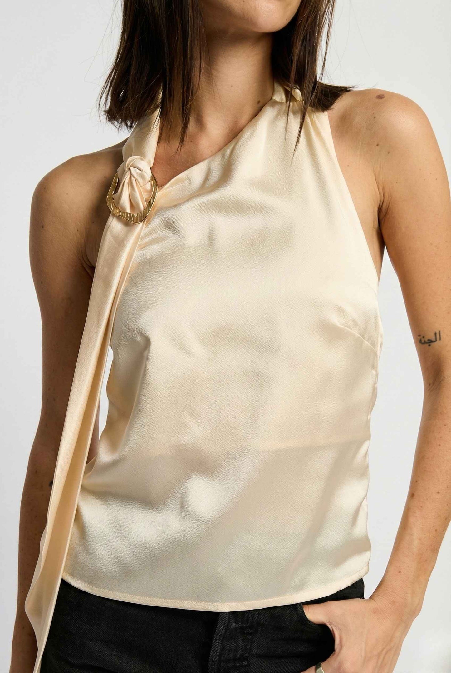 Woman wearing a Aurelia Top Ivory Satin One-Shoulder Scarf Blouse against a white background