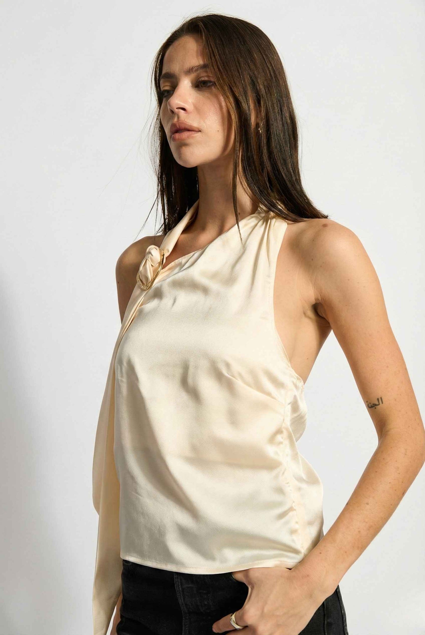 Woman wearing a Aurelia Top Ivory Satin One-Shoulder Scarf Blouse against a white background
