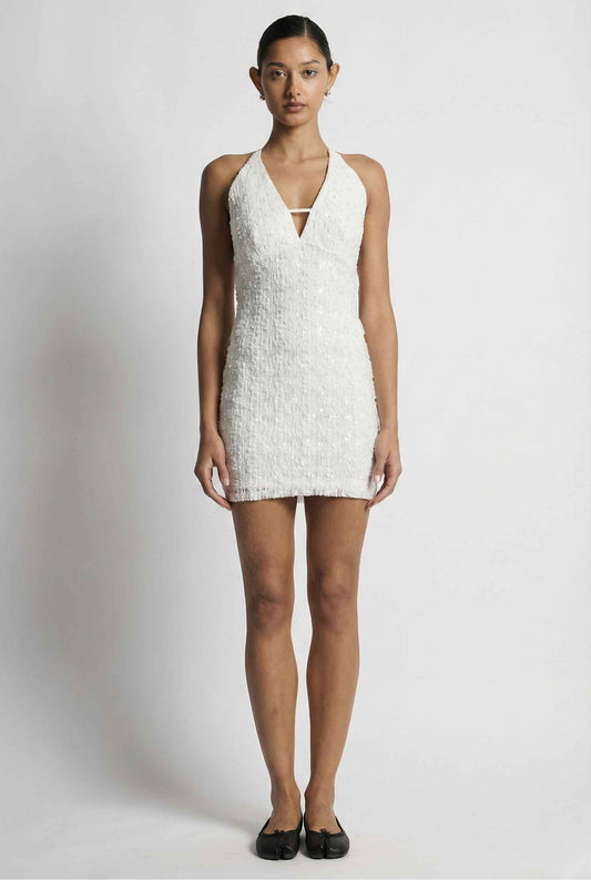 Woman wearing a Bianca Mini Ivory Sequin Plunge Halter Dress on a plain background