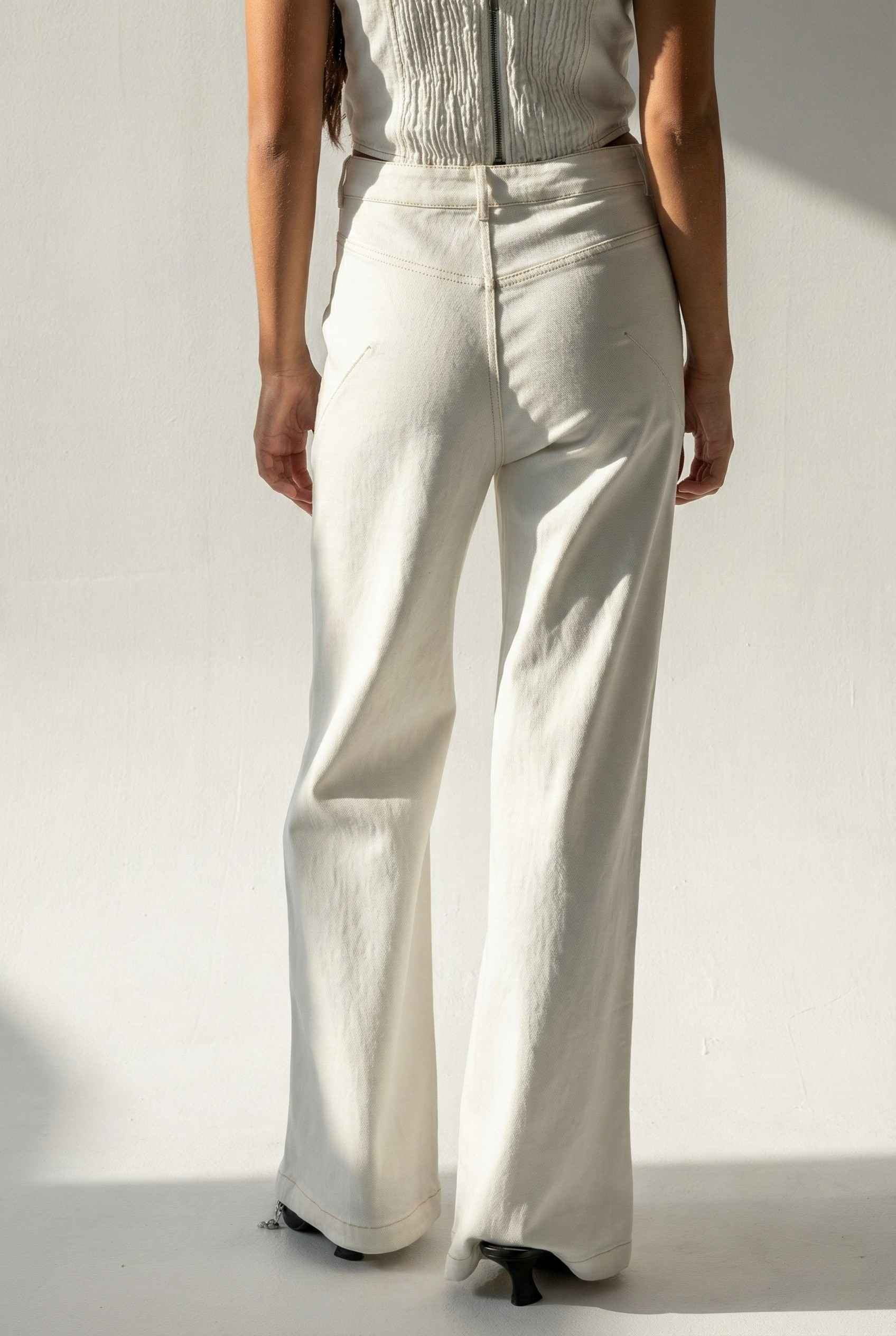 Model wearing Bianca Pants in Off White Cotton-Stretch Seamed Wide-Leg Trousers with matching corset top and heels against plain backdrop