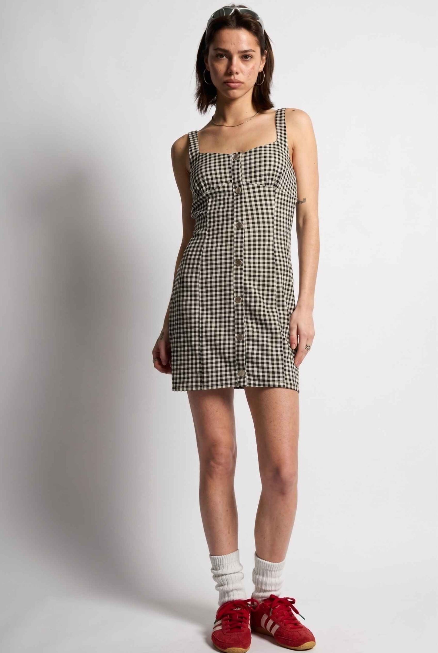 Model wearing Blair Button-Front Gingham Mini Dress Cotton Slip Dress in Black paired with tall socks and casual sneakers