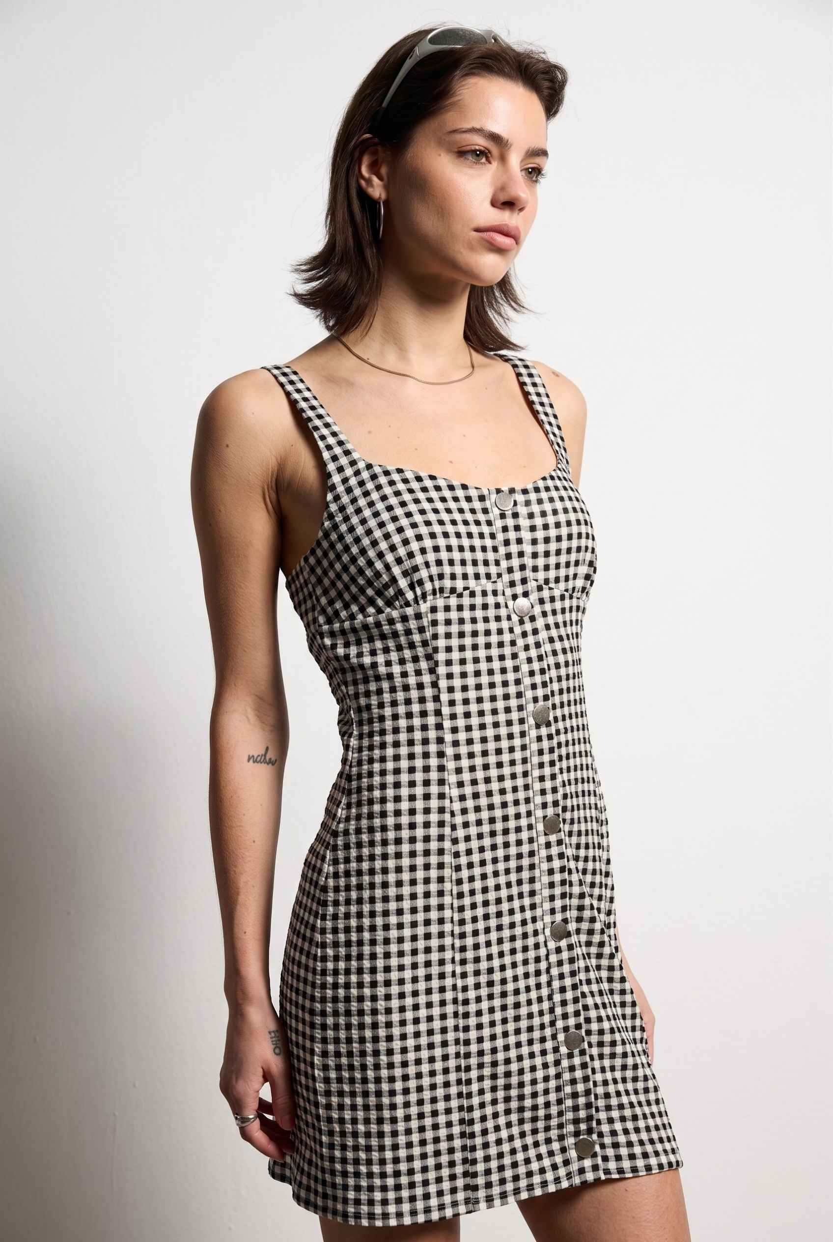 Model wearing Blair Button-Front Gingham Mini Dress Cotton Slip Dress in Black close up side front button detail