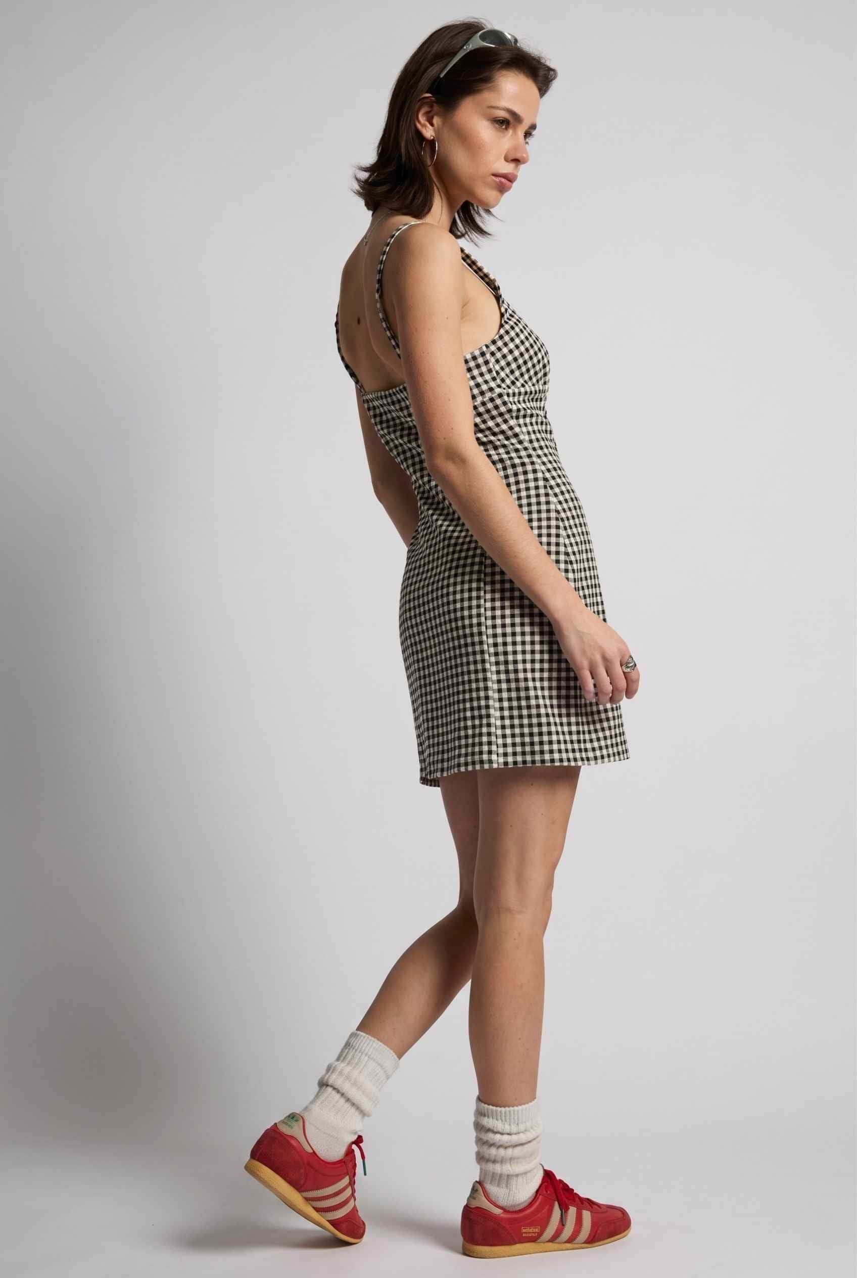 Model wearing Blair Button-Front Gingham Mini Dress Cotton Slip Dress in Black paired with tall socks and casual sneakers