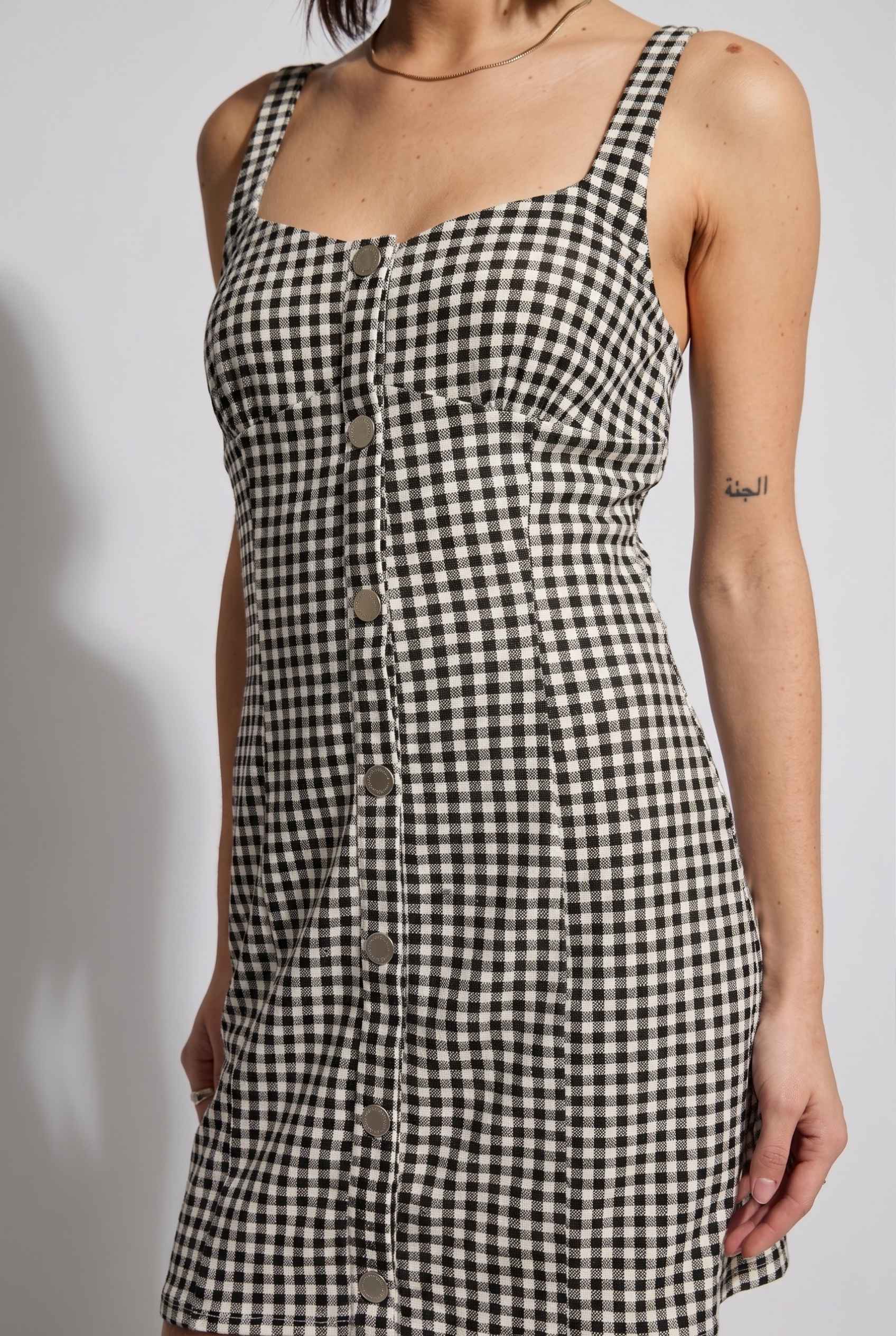 Model wearing Blair Button-Front Gingham Mini Dress Cotton Slip Dress in Black close up button detail front