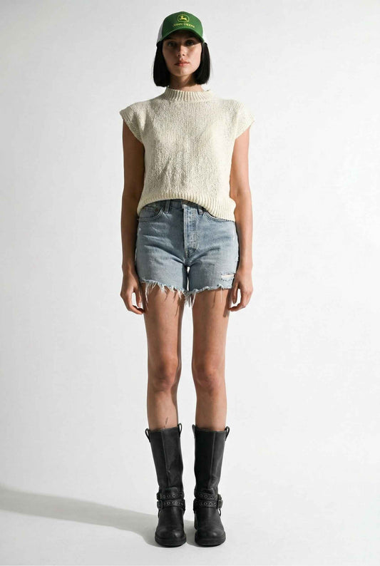 Model wearing Blaire Top in Off White Textured Knit Sleeveless Muscle Tee with denim shorts and tall boots on a plain background