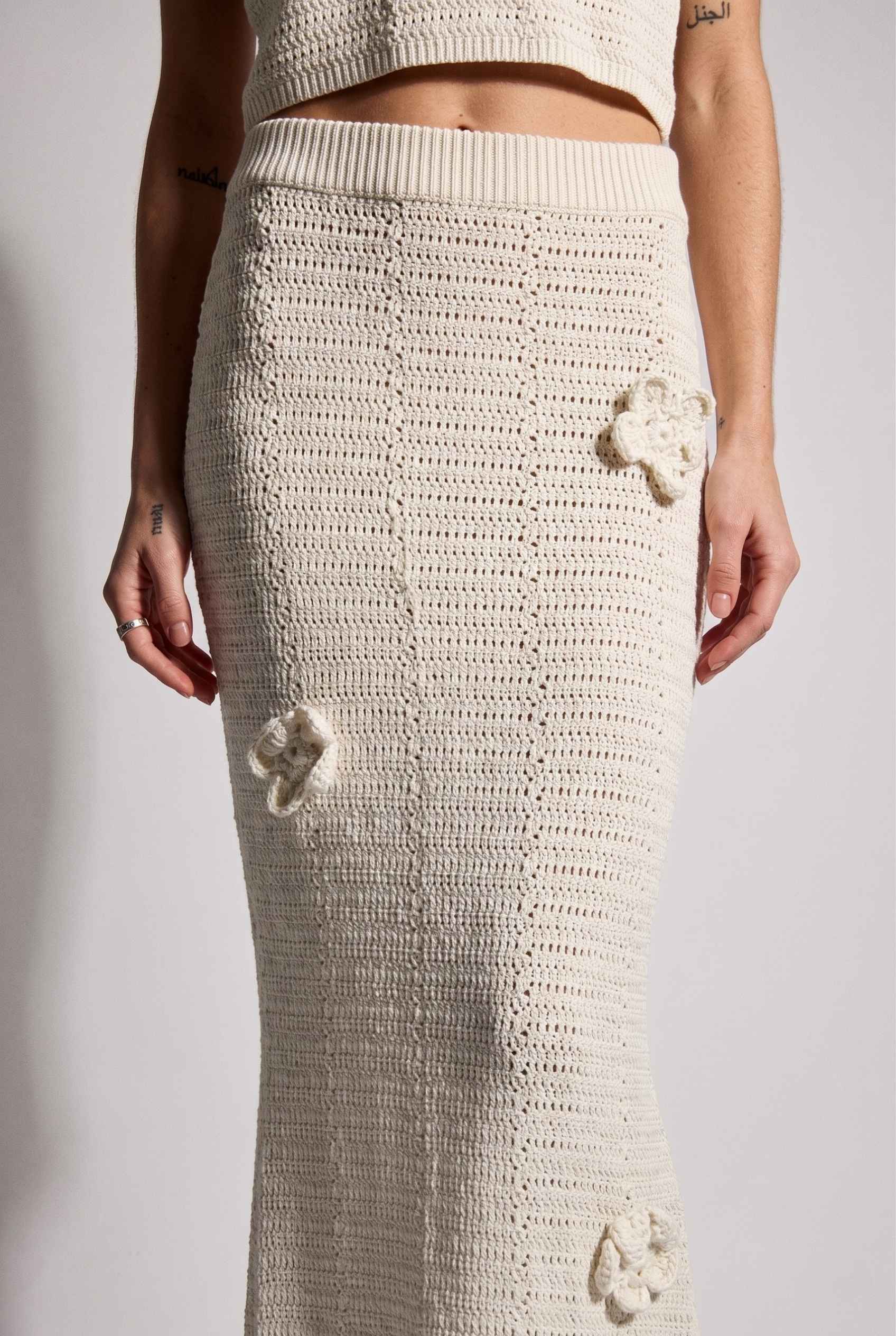 Model wearing Capri Floral Crochet Maxi Skirt in Ivory Cotton Knit Long Skirt paired with matching tank top close up applique detail