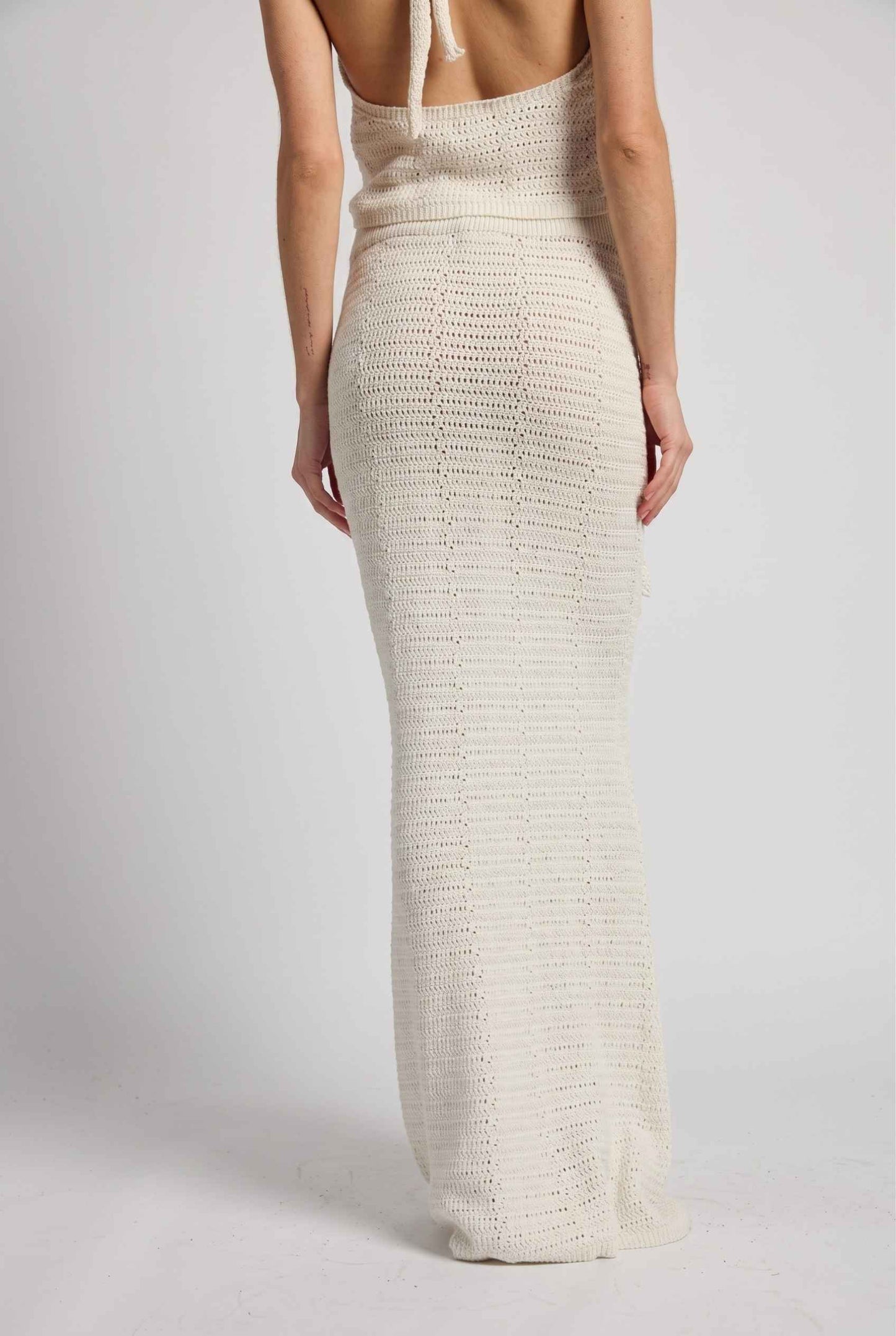 Model wearing Capri Floral Crochet Maxi Skirt in Ivory Cotton Knit Long Skirt paired with matching tank top back view