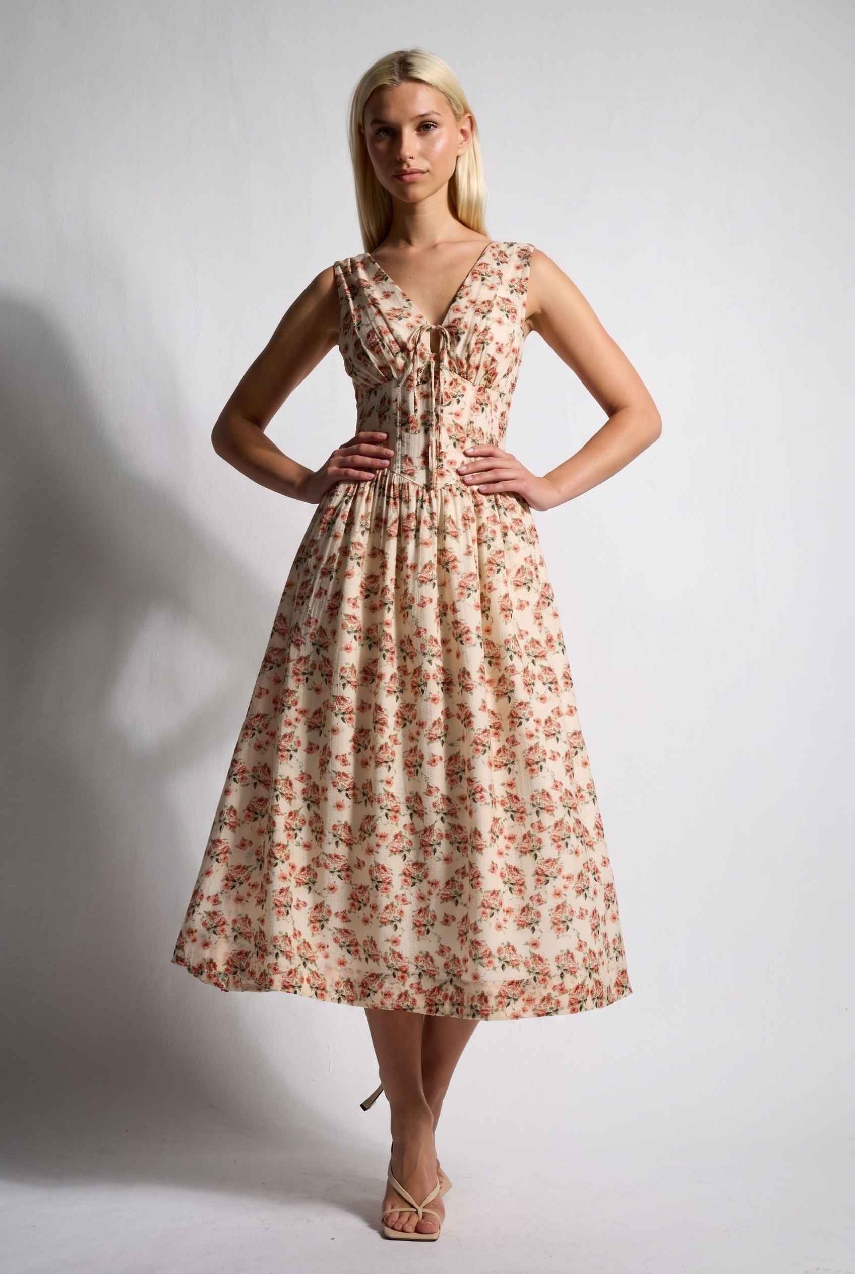 Model wearing Carolina Floral V-Neck Fit and Flare Dress Corset Midi Dress in Ivory paired with kitten heels