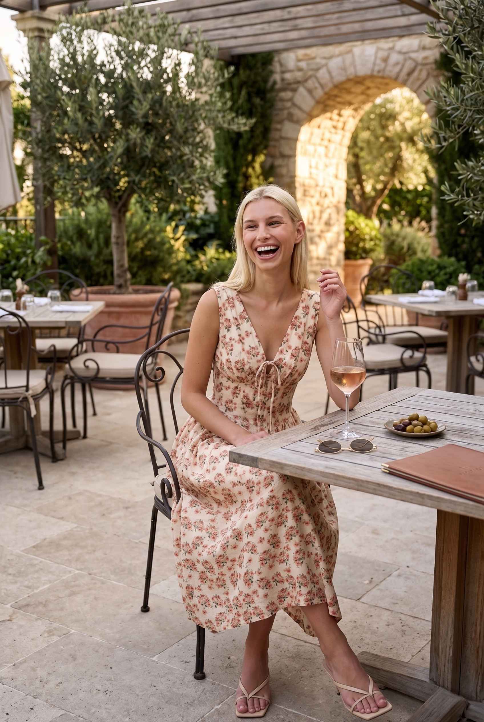 Model wearing Carolina Floral V-Neck Fit and Flare Dress Corset Midi Dress in Ivory paired with kitten heels sitting on luxury brunch patio sipping wine