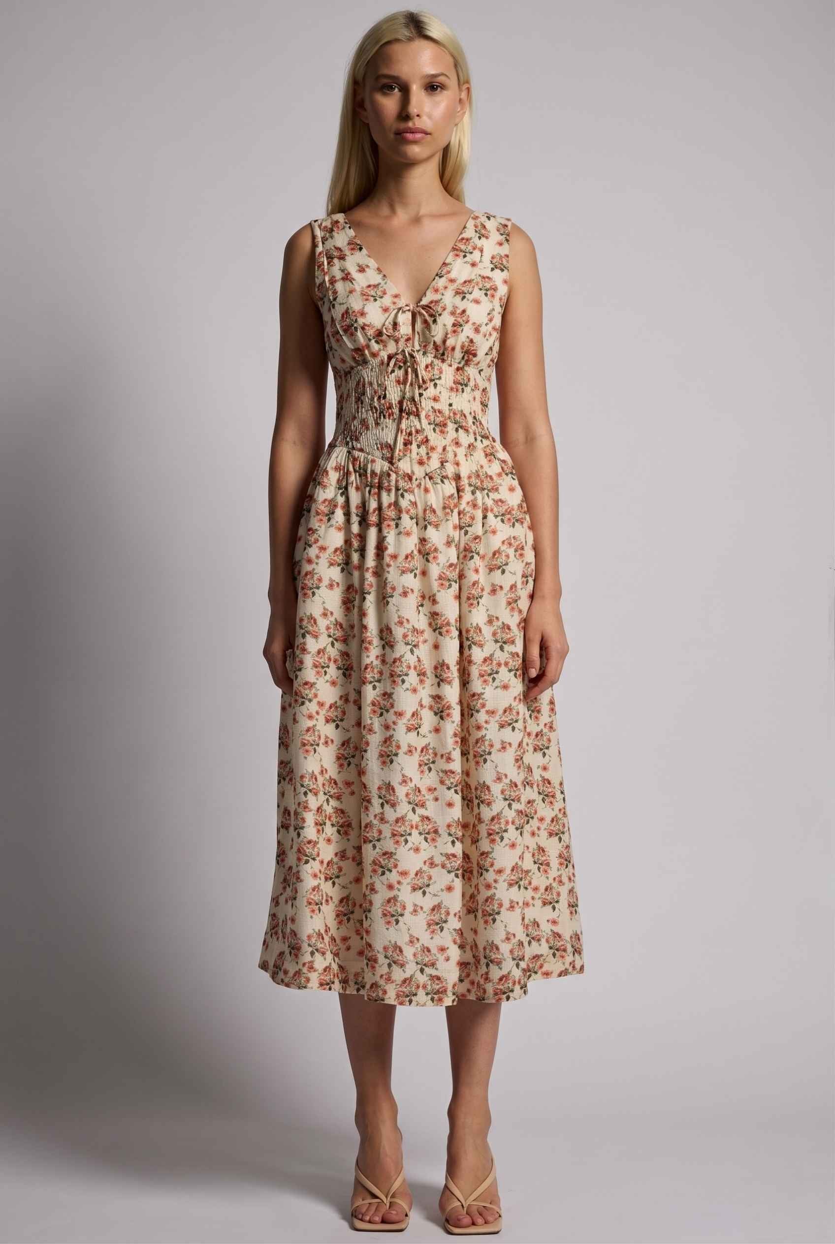 Model wearing Carolina Floral V-Neck Fit and Flare Dress Corset Midi Dress in Ivory paired with kitten heels