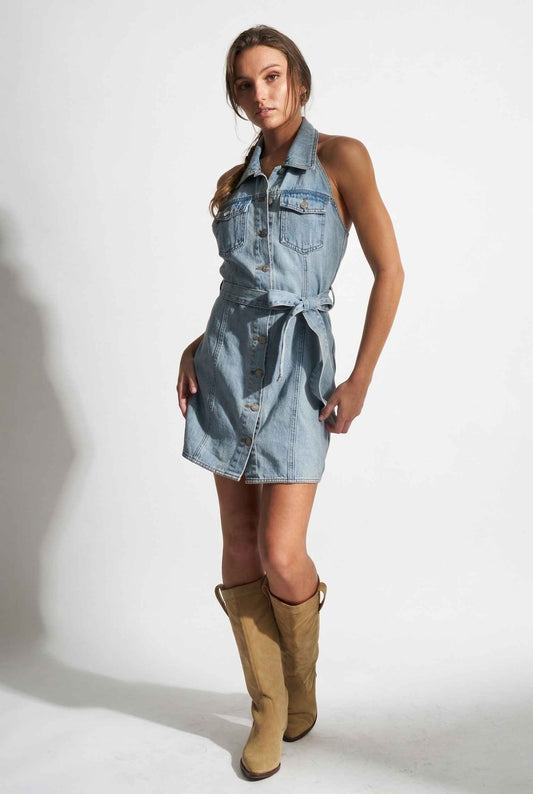 Model wearing Cassidy Mini in Light Wash Denim Button-Front Dress paired with riding boots