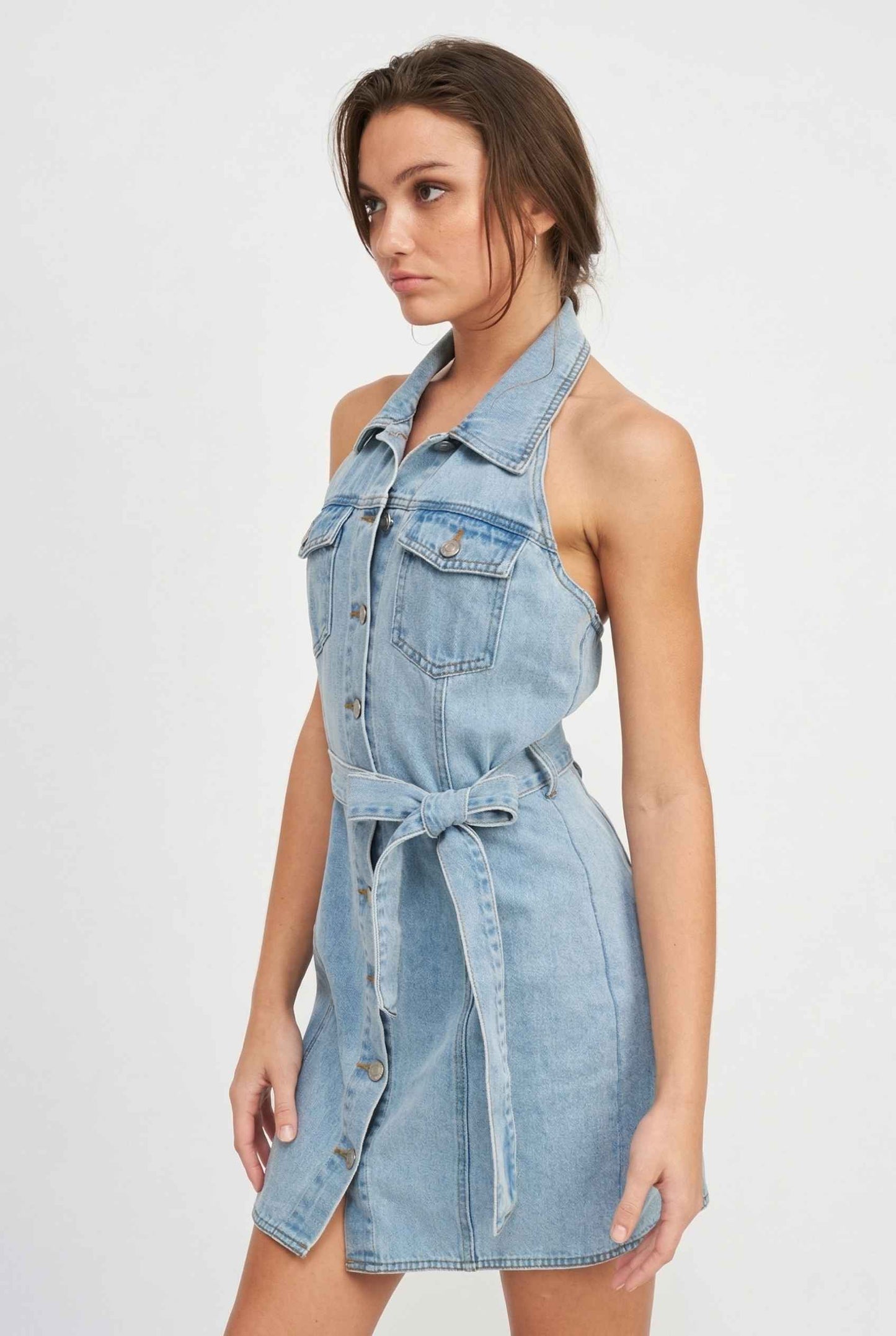 Model wearing Cassidy Mini in Light Wash Denim Button-Front Dress halter neckline detail
