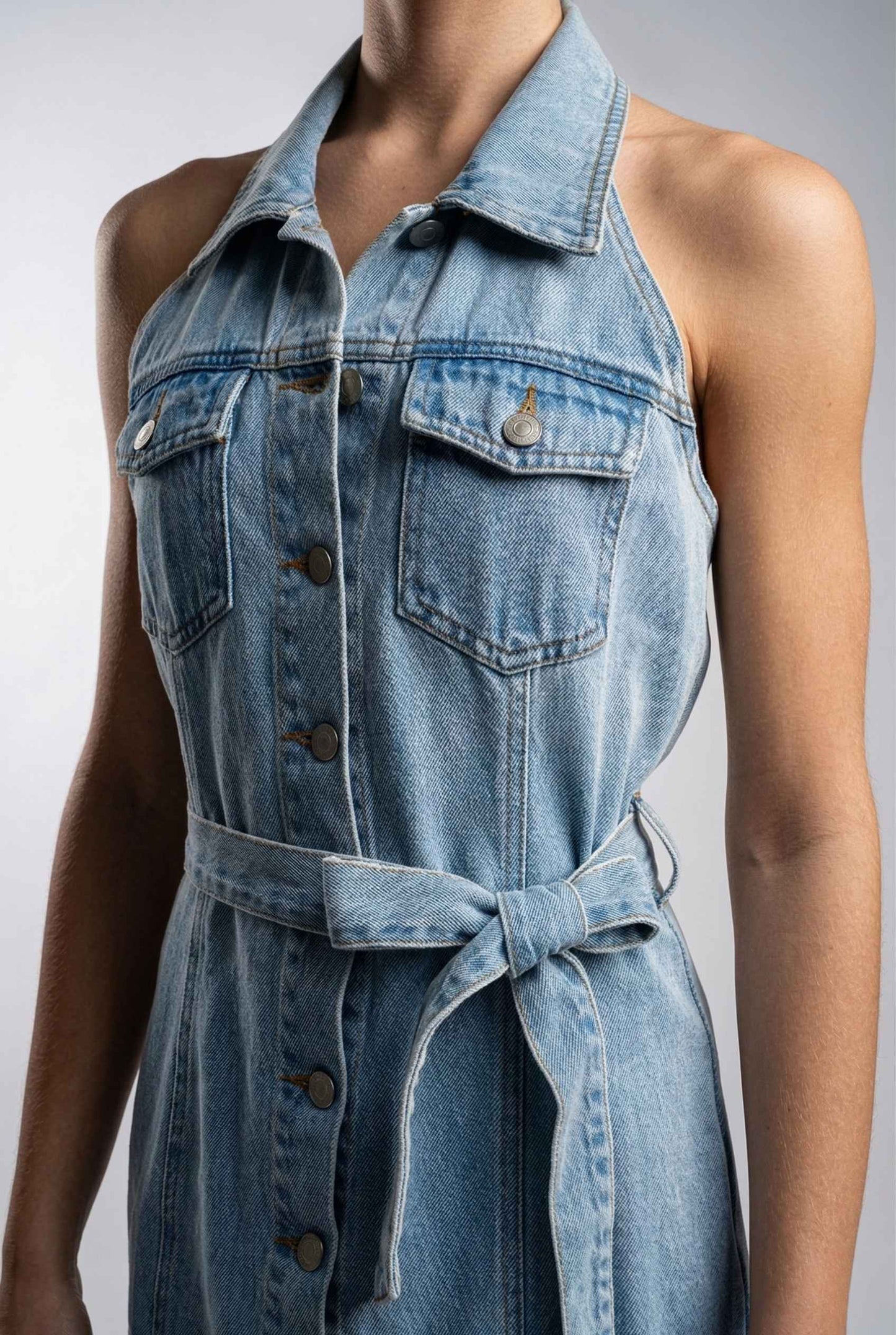 Model wearing Cassidy Mini in Light Wash Denim Button-Front Dress close up tie detail