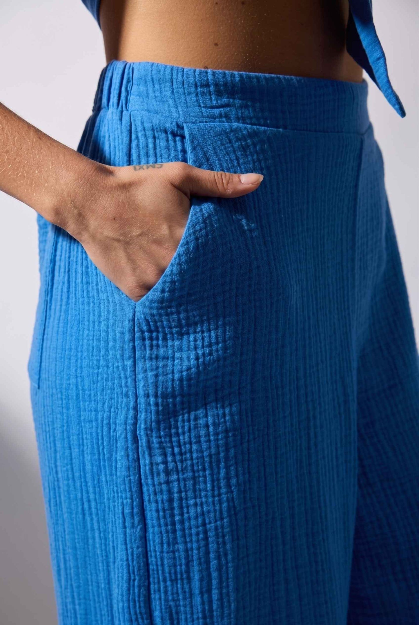 Model wearing Celine High-Waisted Gauze Pant 100% Cotton Wide-Leg Resort Pant in Blue close up fabric detail