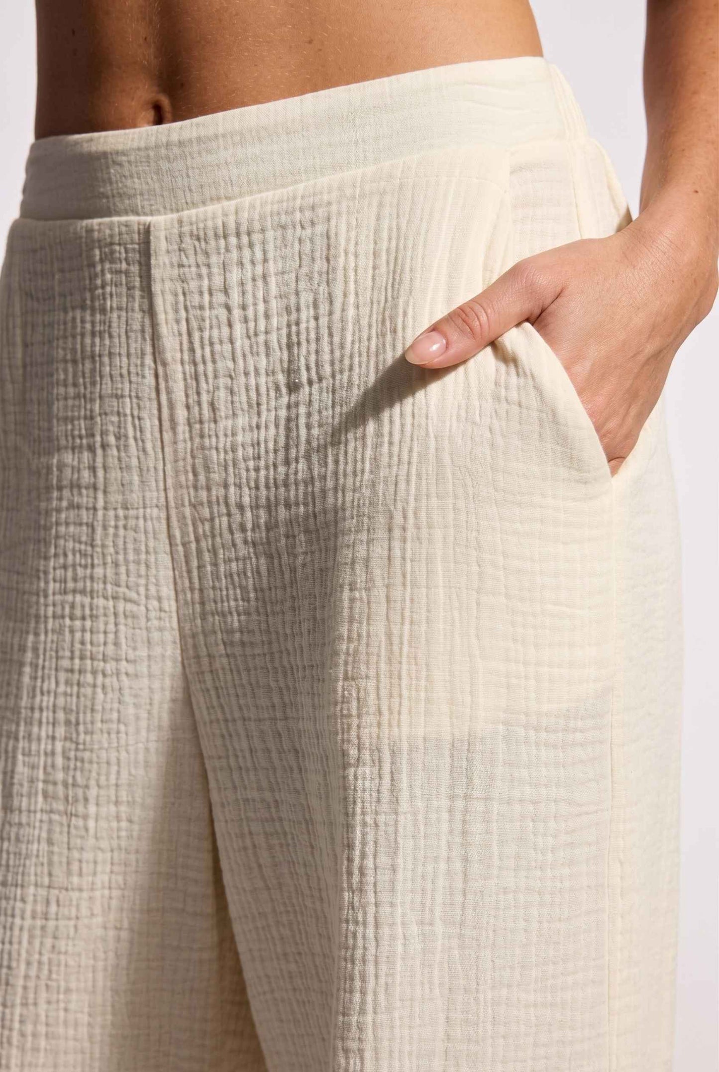 Model wearing Celine High-Waisted Gauze Pant 100% Cotton Wide-Leg Resort Pant in Off White close up fabric detail