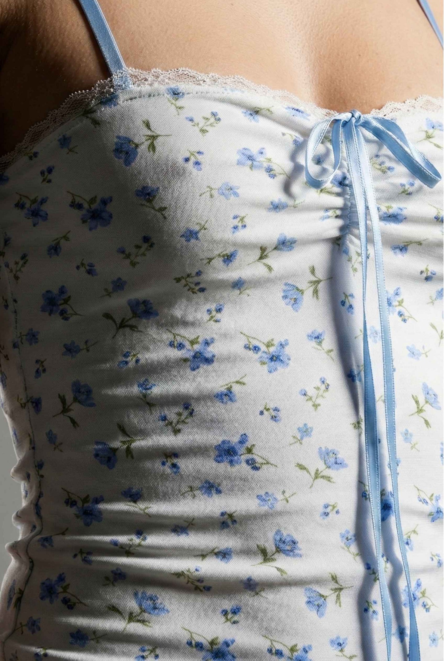 Chloe Mini Blue Floral Mesh Tie Front Dress with blue flowers on a person, close-up view.