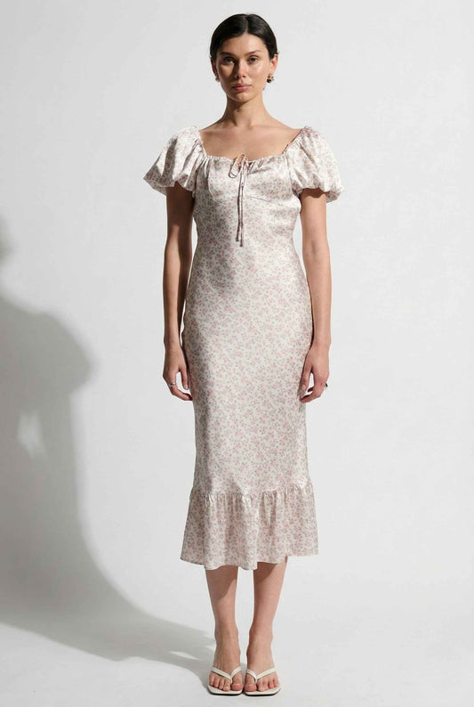 Woman wearing a Clara Midi Pink Puff Sleeve Floral Satin Dress against a white background