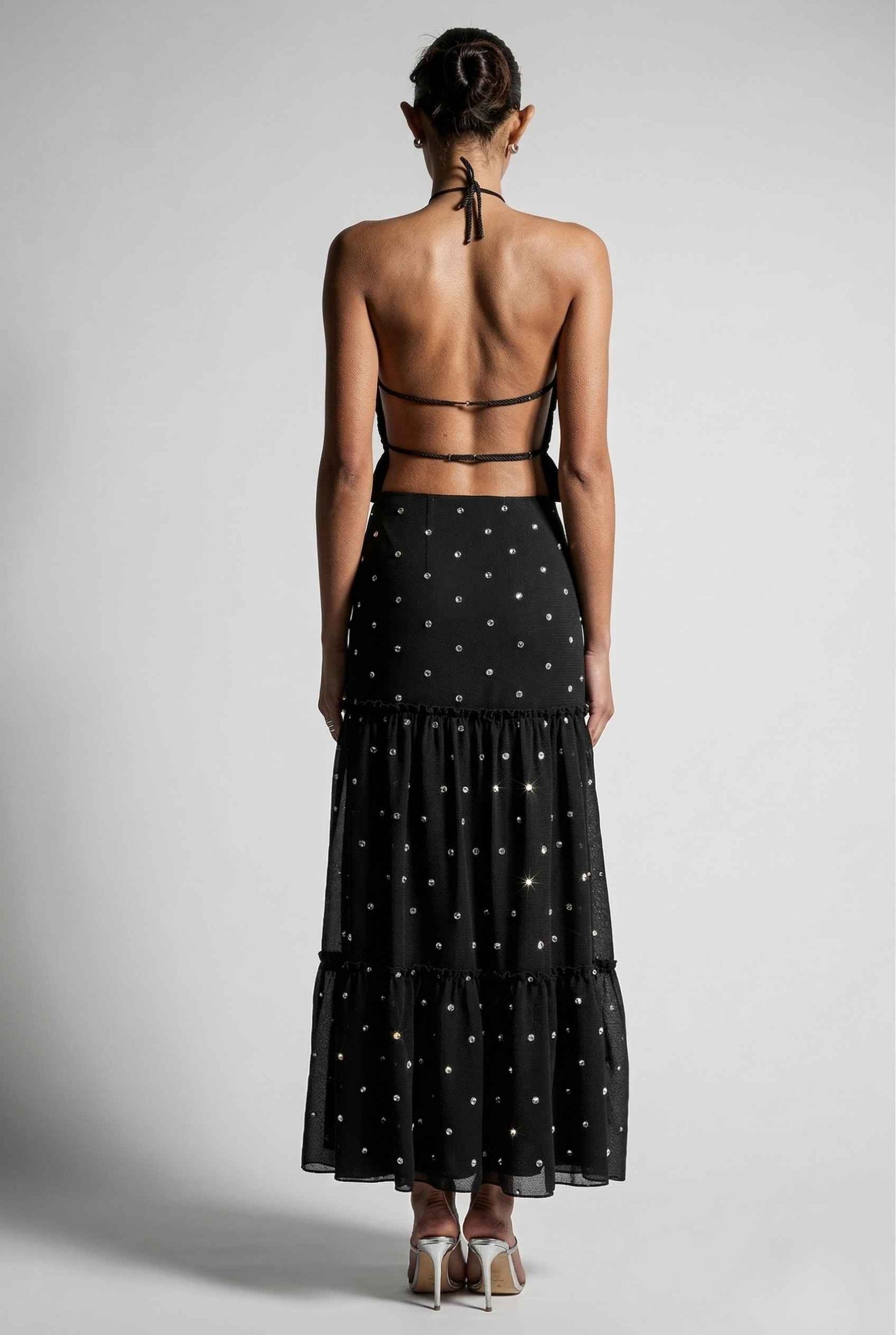 Woman wearing  a Clara Skirt Black Tiered Ruffle Polka Dot Midi Skirt with a sheer overlay on a gray background