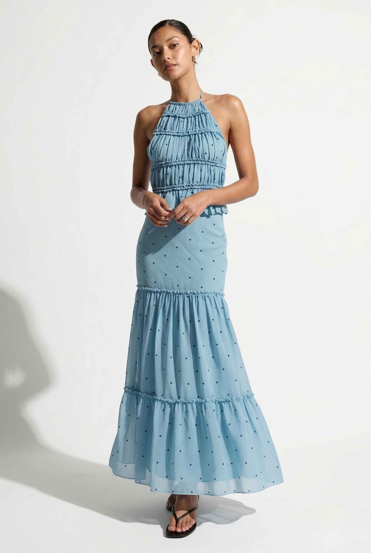 Woman wearing a Clara Skirt Blue Tiered Ruffle Polka Dot Midi Skirt on a plain background