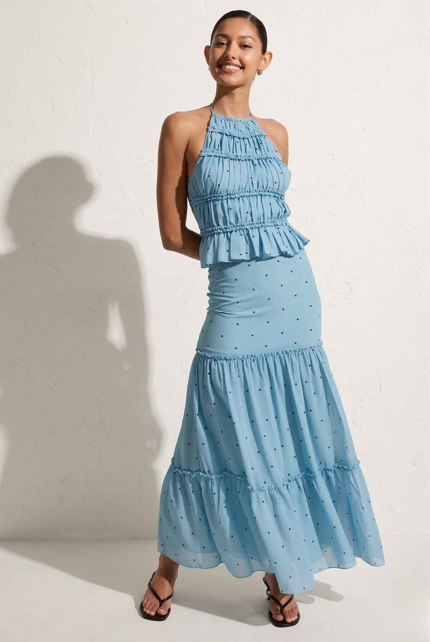 Woman wearing a Clara Skirt Blue Tiered Ruffle Polka Dot Midi Skirt against a plain background
