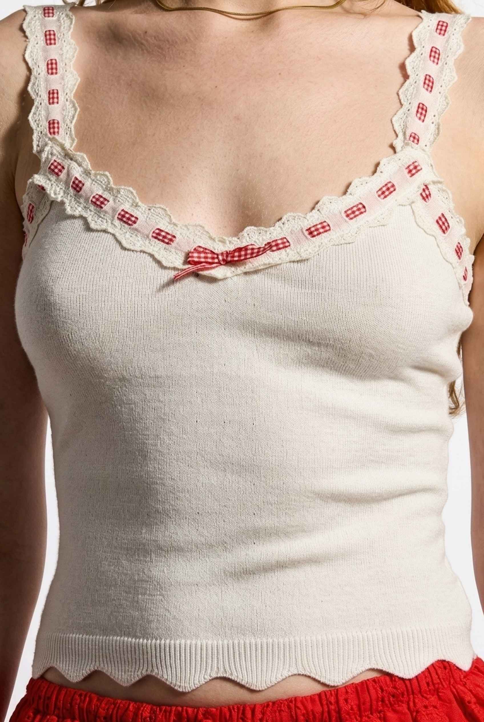 Model wearing Clara Top in White Knit Tank with Scallop Trim & Bow paired with ruffle mini skirt