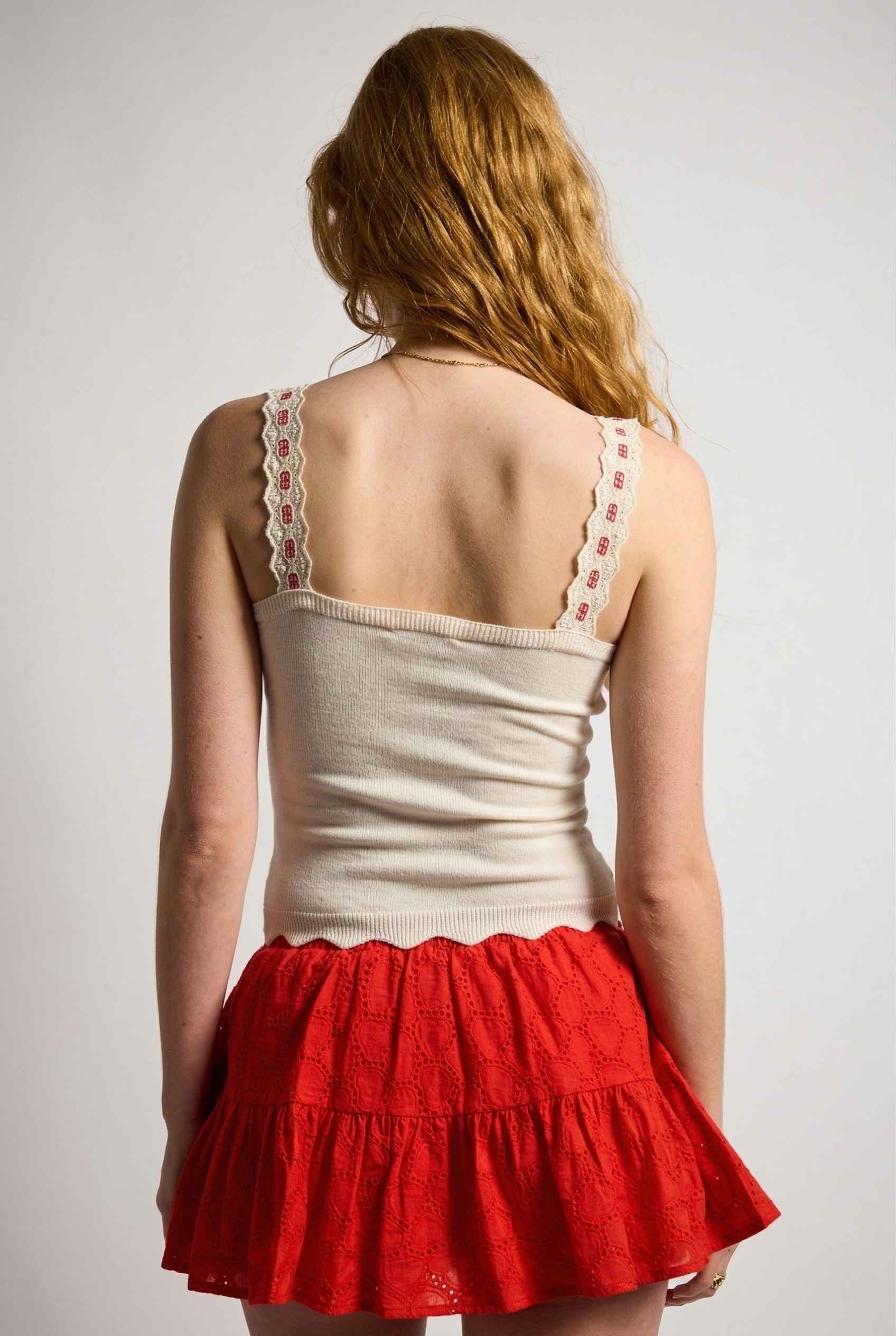 Model wearing Clara Top in White Knit Tank with Scallop Trim & Bow paired with ruffle mini skirt 