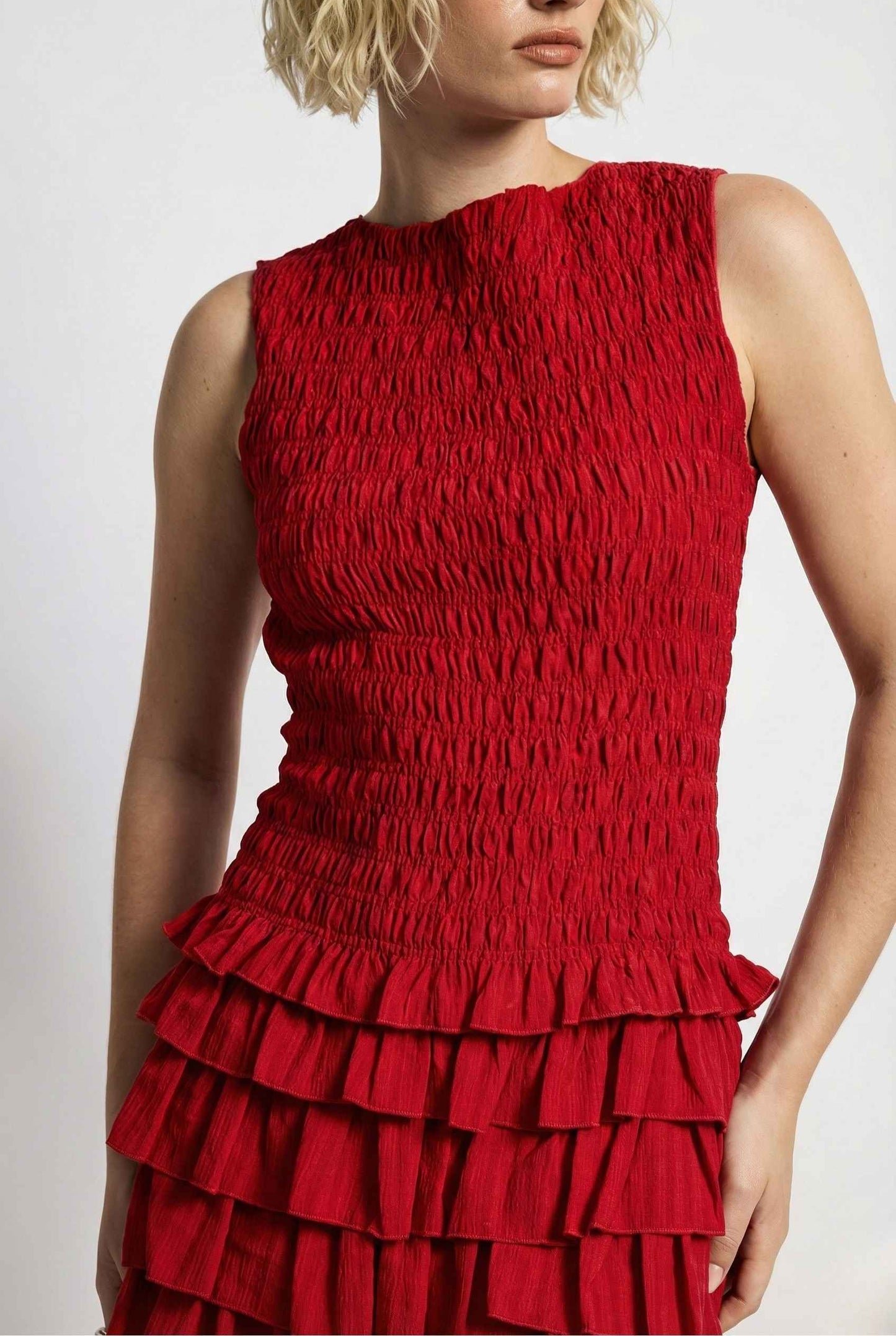 Cleo Mini Red Smocked Ruffle Sleeveless Dress worn by a model on a white background