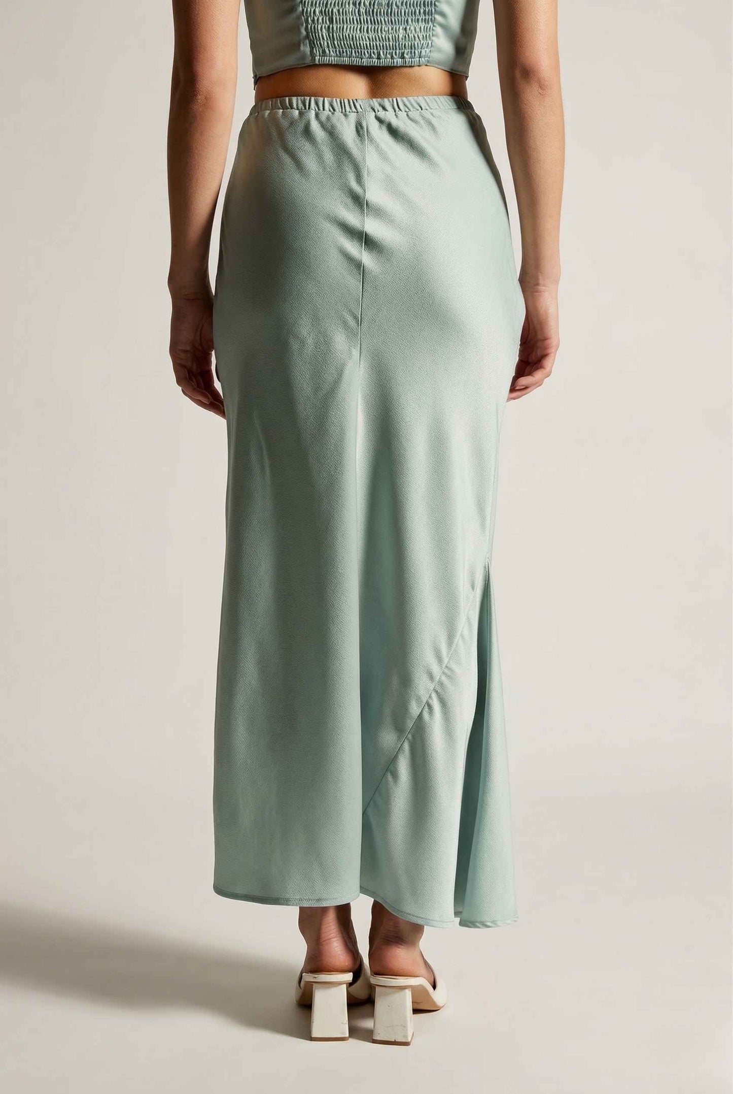 Woman wearing a Cleo Skirt Light Blue Satin Drawstring Maxi Skirt on a plain background