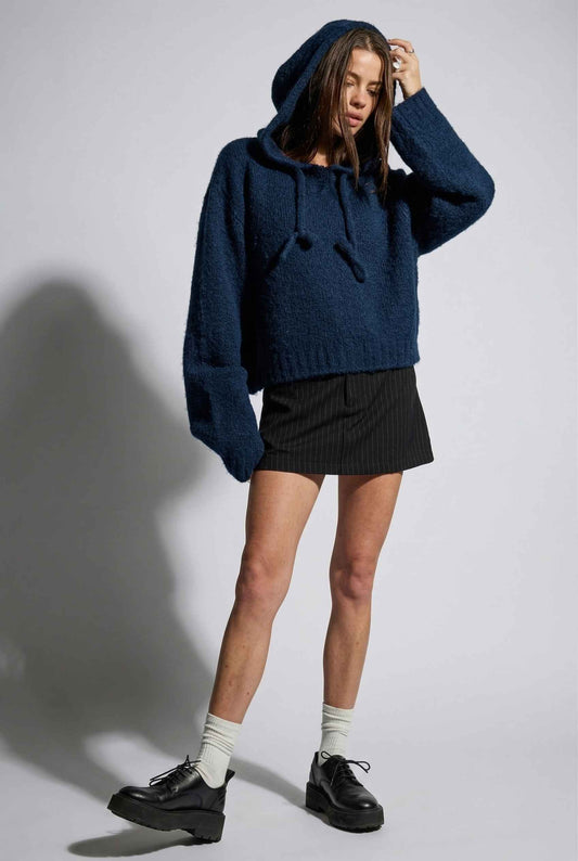 Model wearing Cleo Top in Navy Fuzzy Wool-Blend Knit Hoodie with Drawstrings with pinstripe mini skirt and loafers
