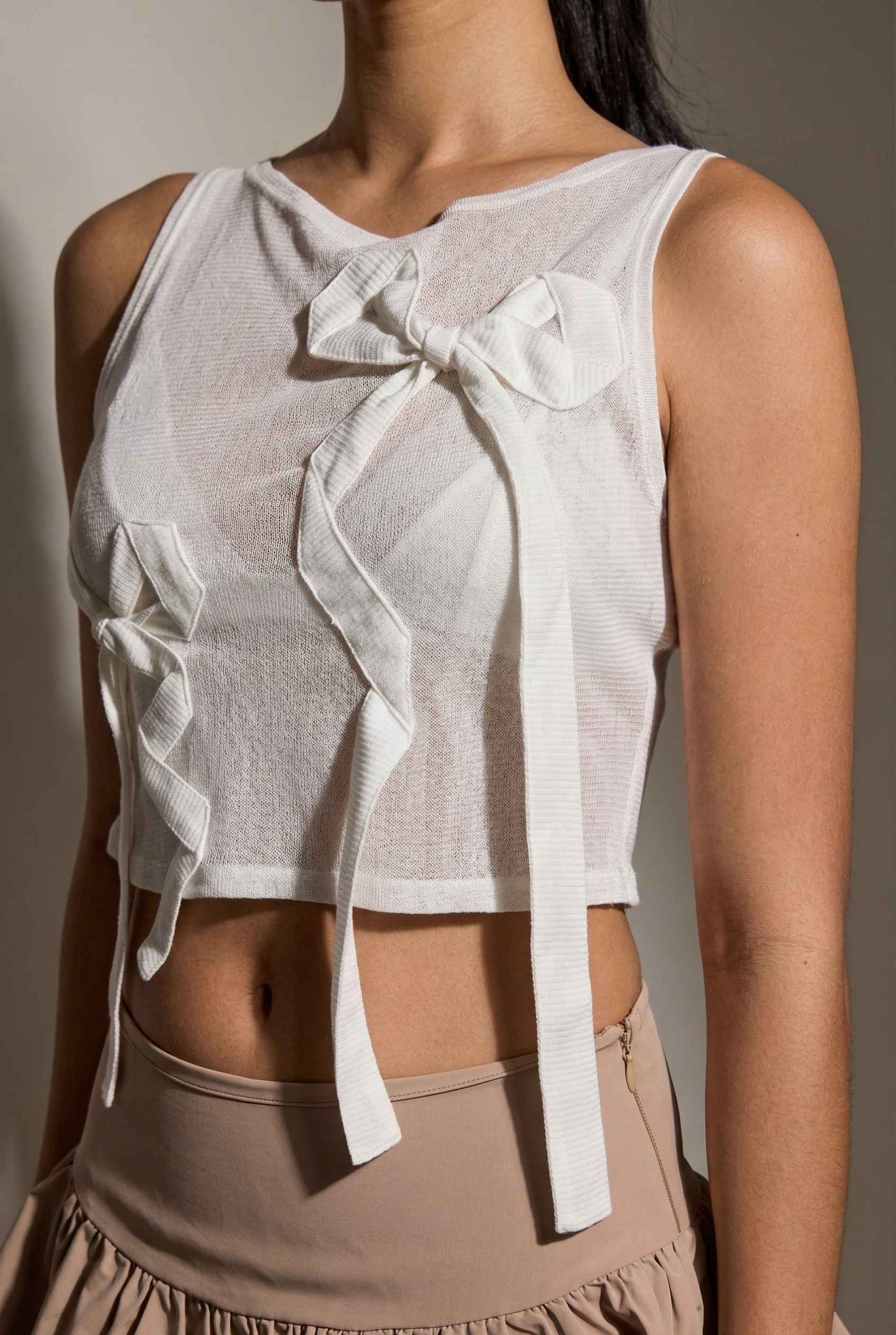 Colette Top White Sheer Mesh Ribbon Bow Tank with bow details worn by a person against a neutral background