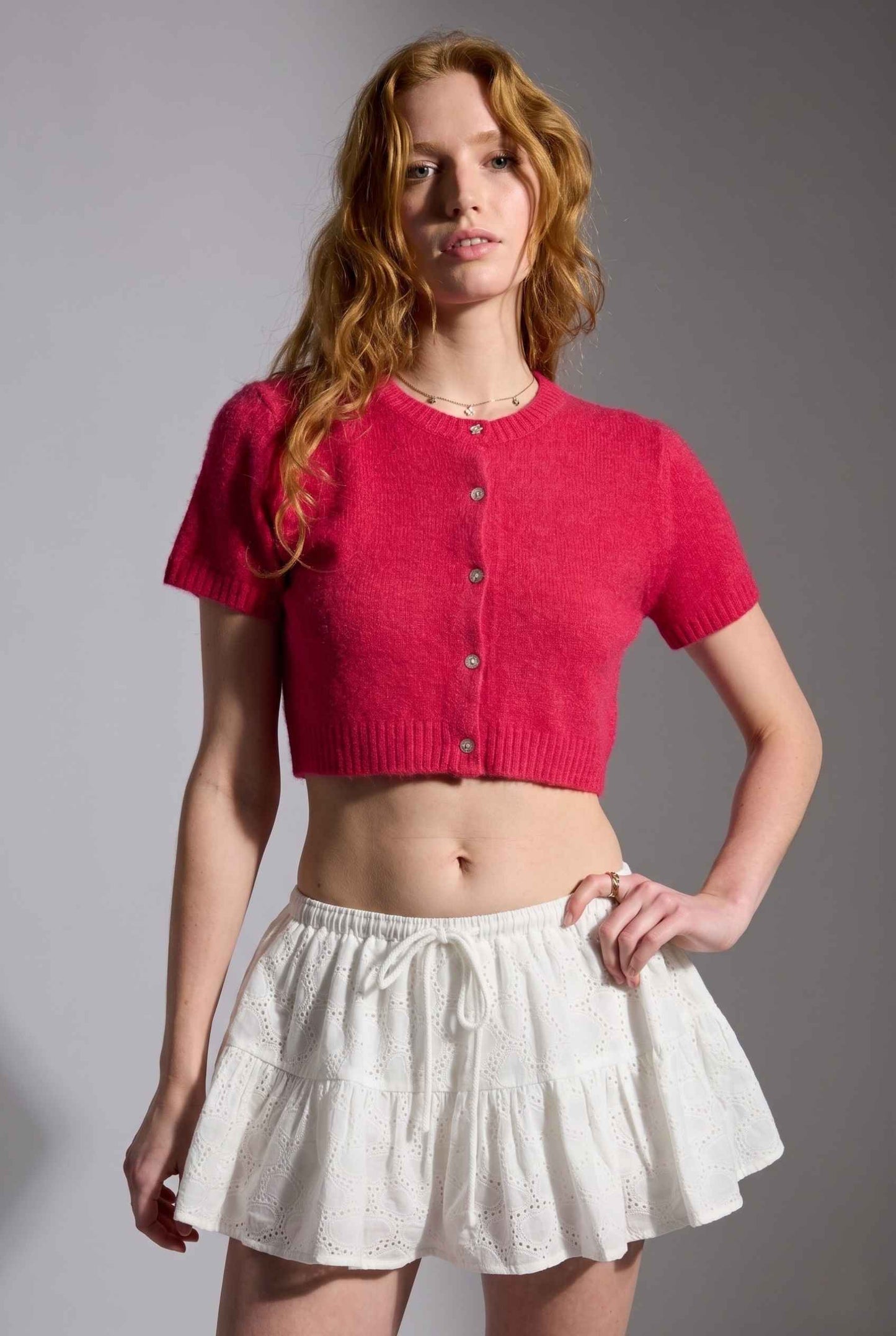 Model wearing Corinne Cotton Skort Pleated Ruffle Mini Skort in White with cropped short sleeve cardigan