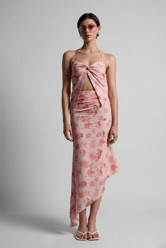 Woman wearing a Daphne Skirt Pink Floral Ruched Asymmetrical Midi Skirt against a gray background
