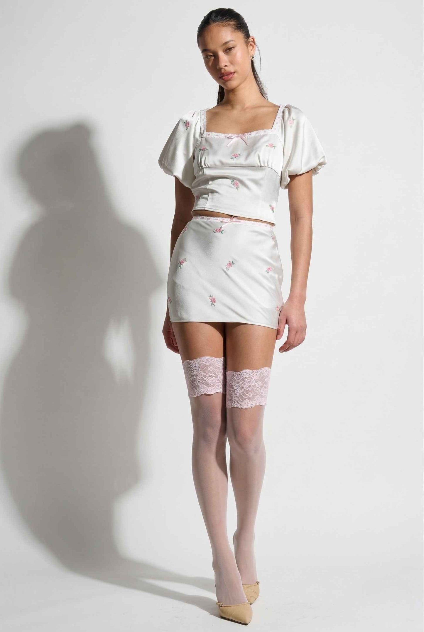 Woman wearing a Elara Skirt White Satin Mini Skirt with Dainty Pink Florals