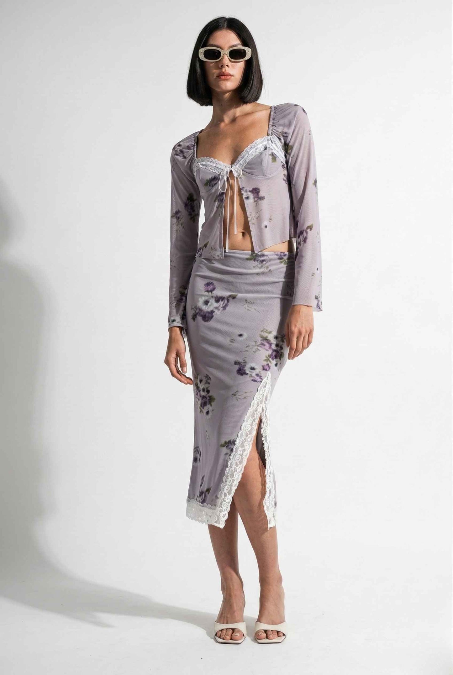 Woman wearing a Elara Top Lavender Floral Lace Trim Fly-Away Cardigan with a white background